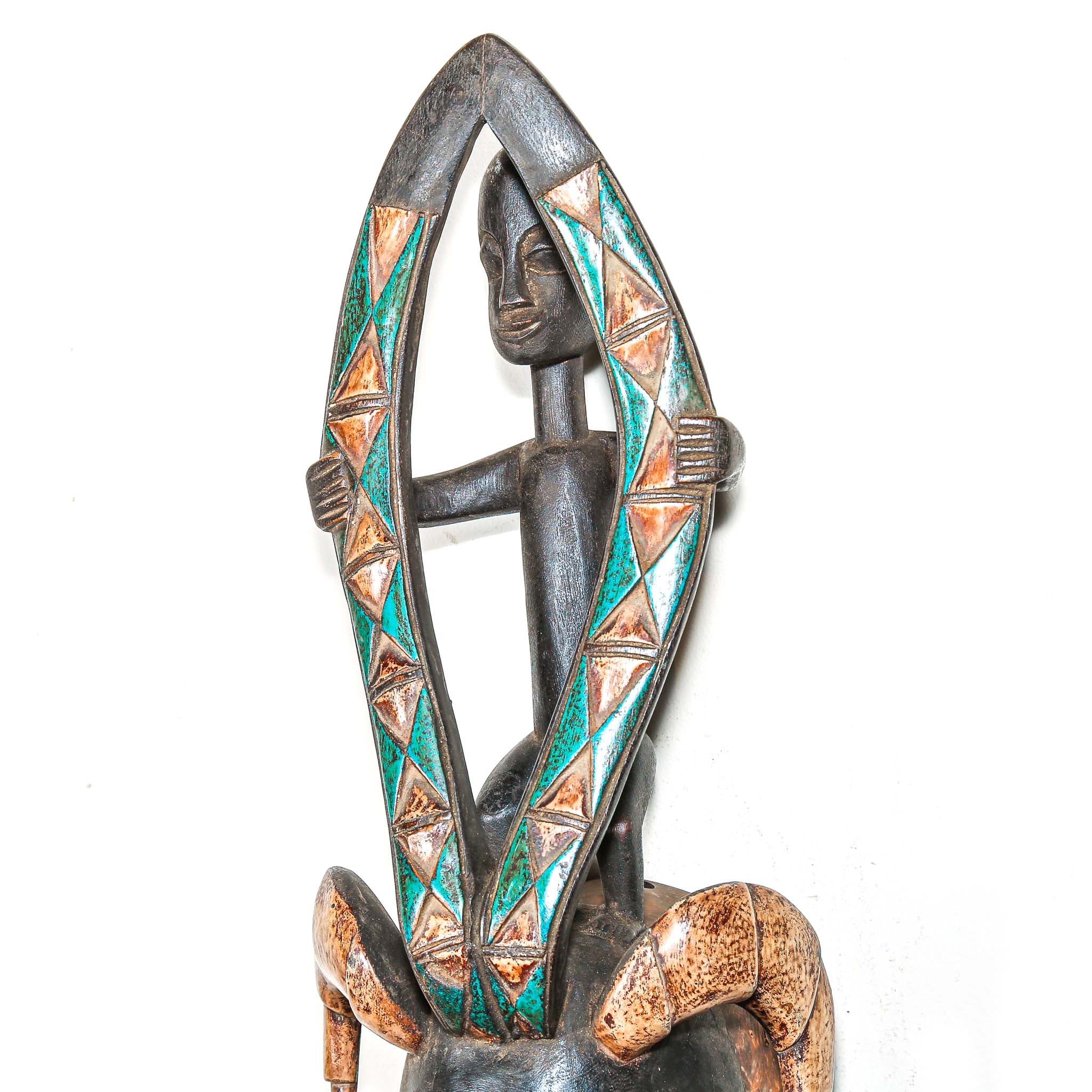 Decorative hand made wooden mask by an African artist with intricate designs on a white background