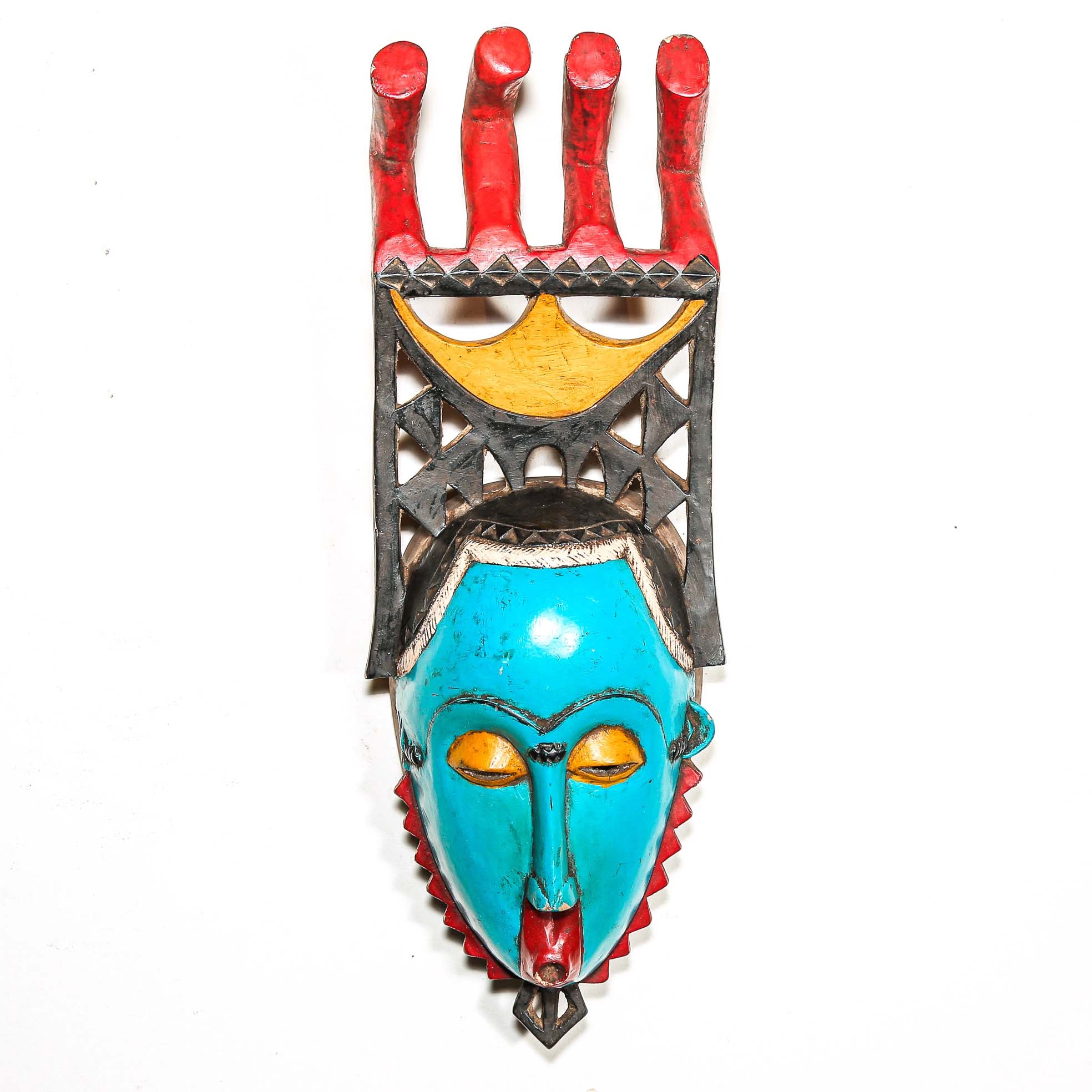 Colorful African wall mask with turquoise face, red and yellow accents on a white background