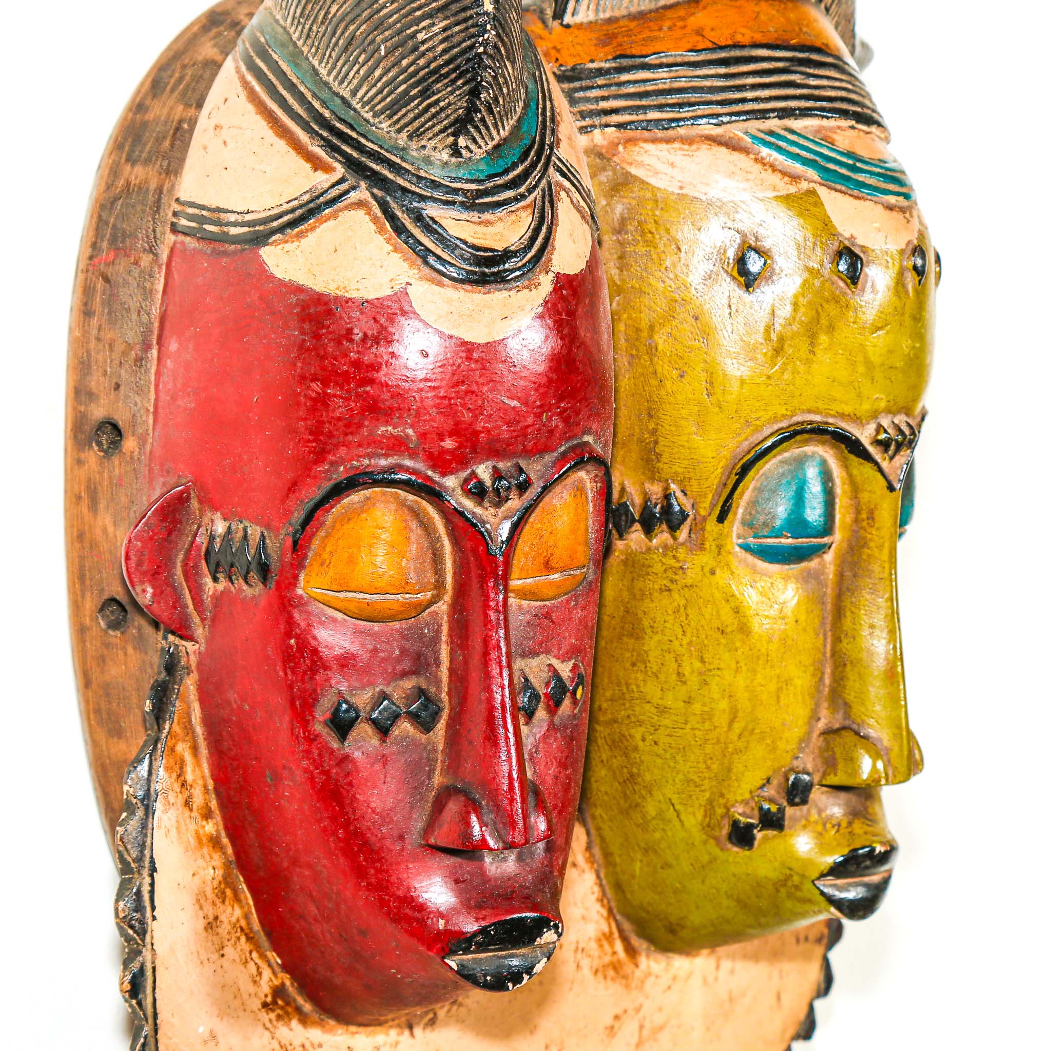 Two colorful African masks, one red and one green, on a white background