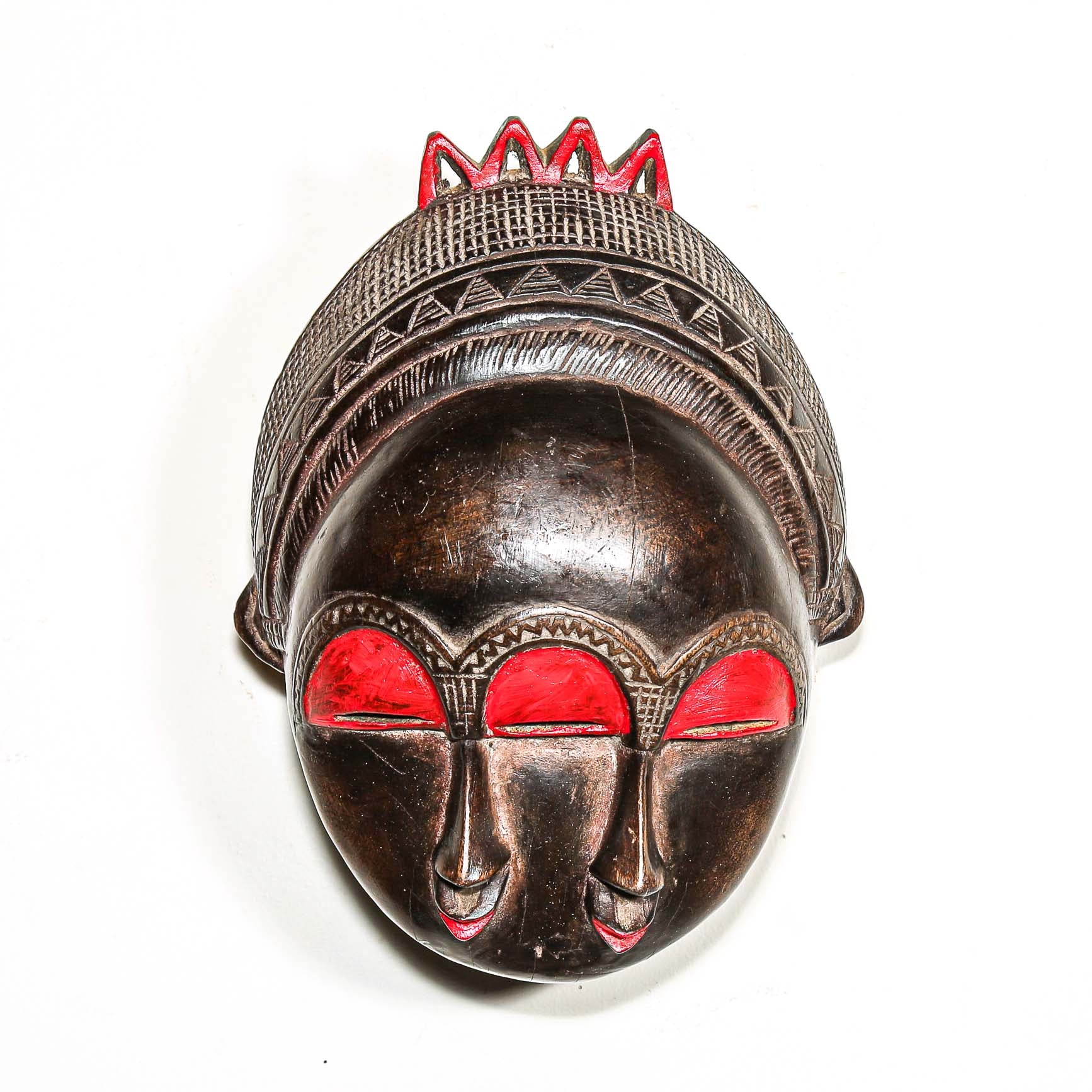Decorative colorful african wooden mask with red accents on a white background