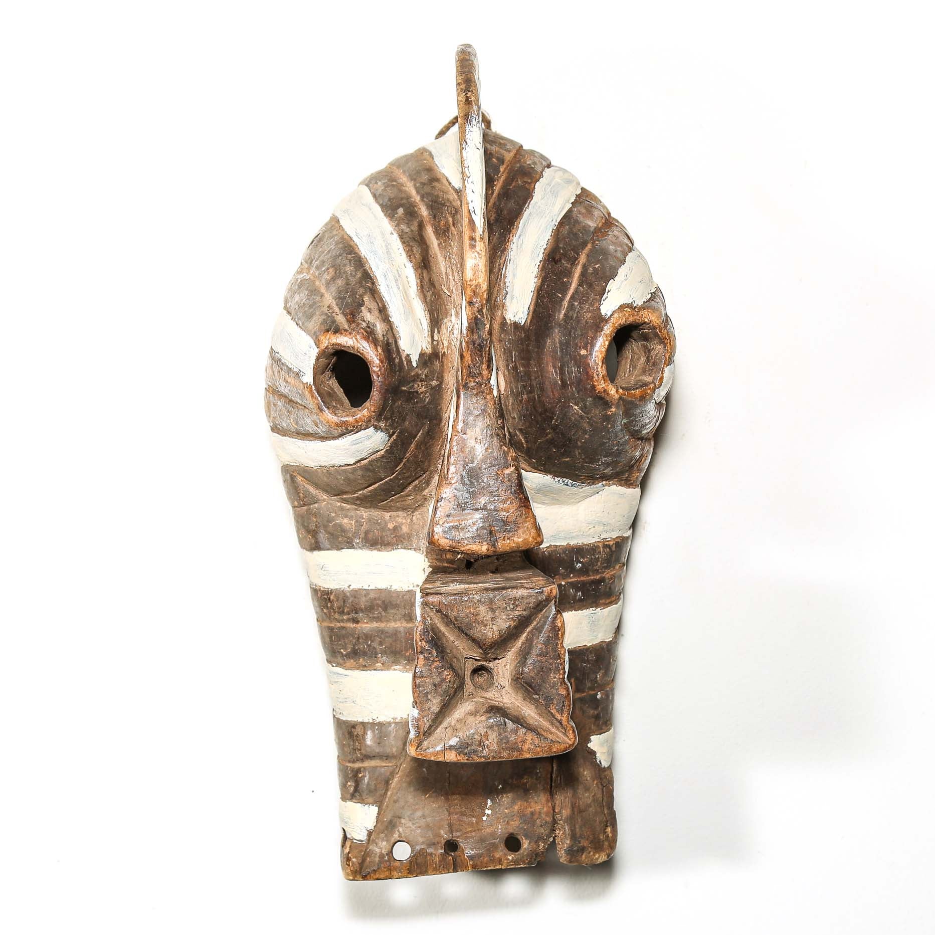 Wooden mask with white stripes on a white background