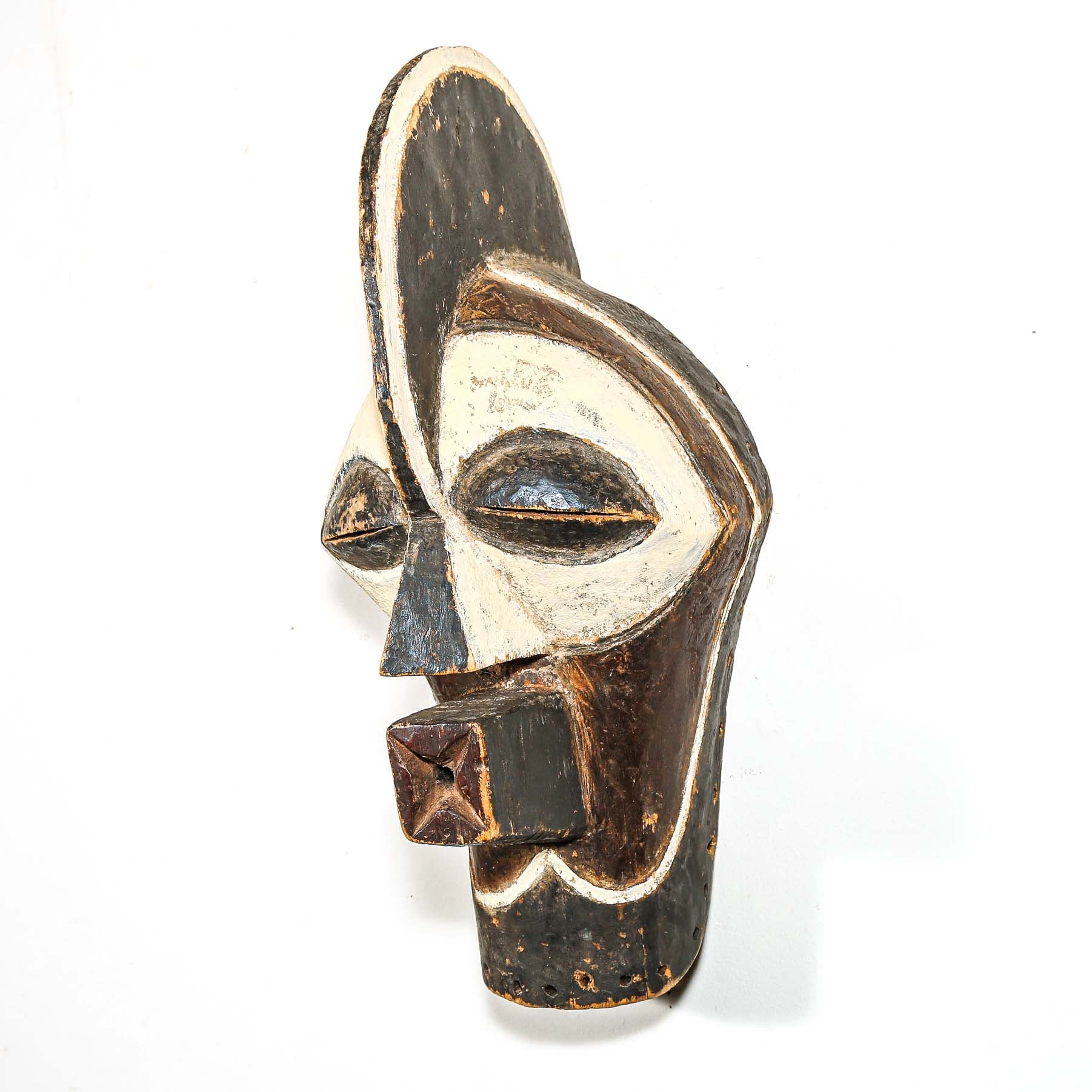 Wooden mask with black and white design on a white background