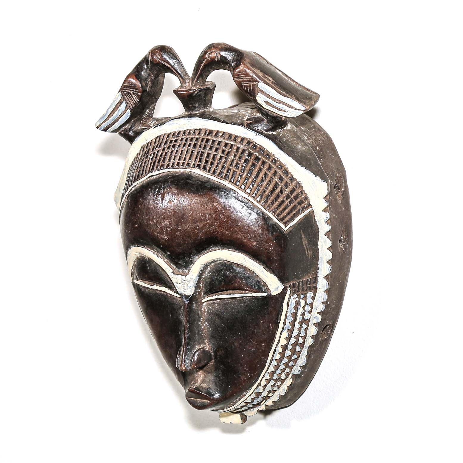 Decorative fine art african mask with white accents on a white background. Traditional art for sale