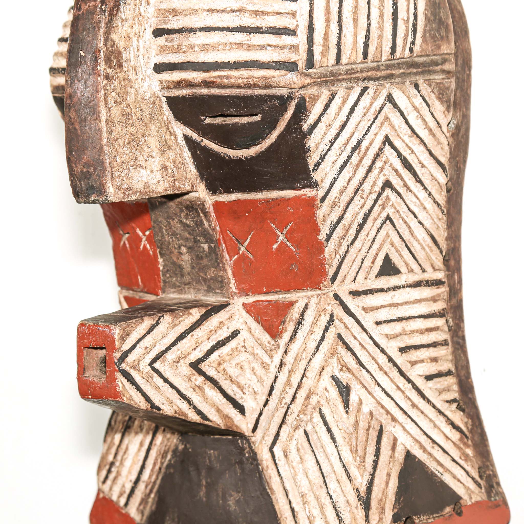 African art piece, specifically a wooden mask with geometric patterns on a white background. Tribal African art for sale.