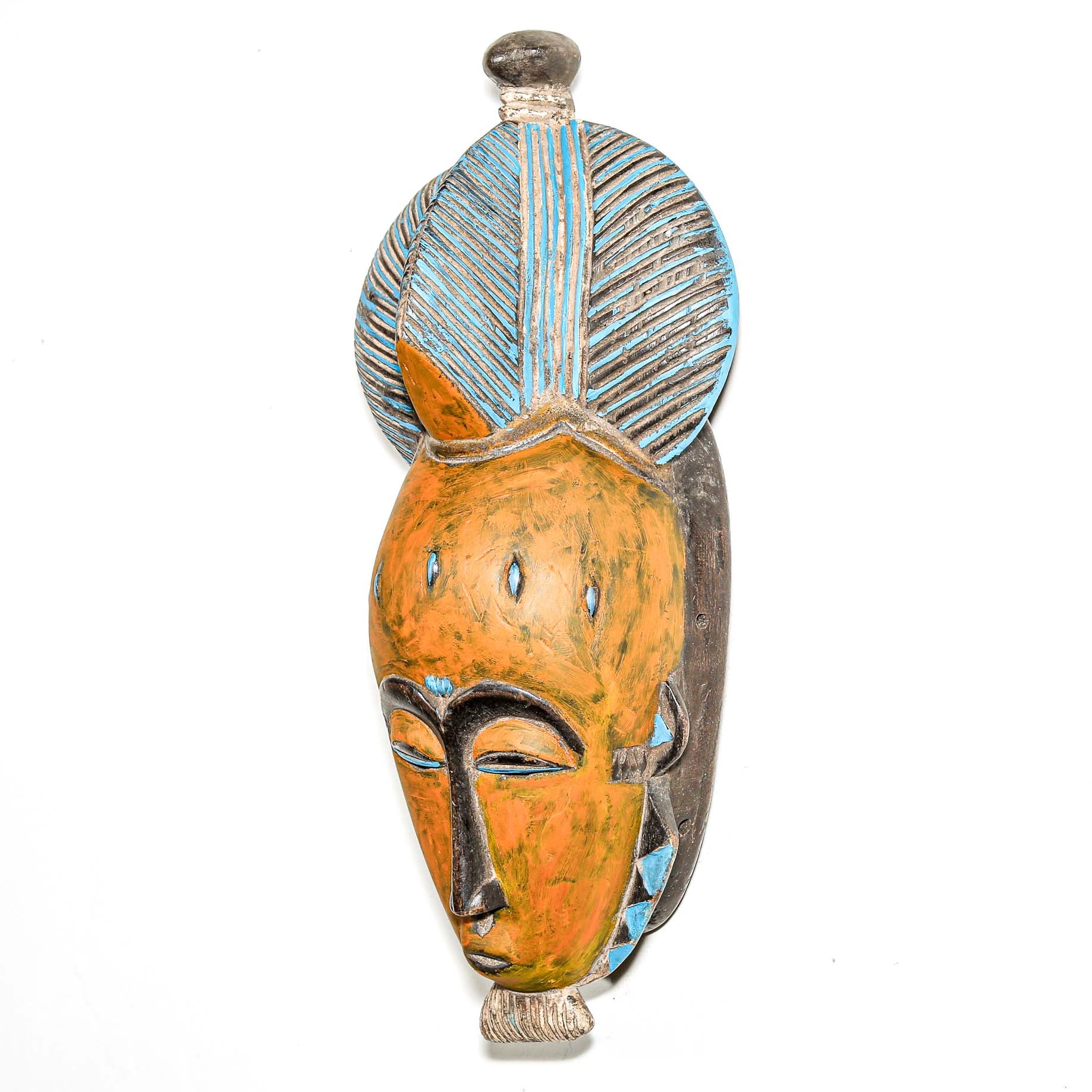 African art piece, specifically a yellow and blue wooden mask with geometric patterns on a white background. Tribal African art for sale.