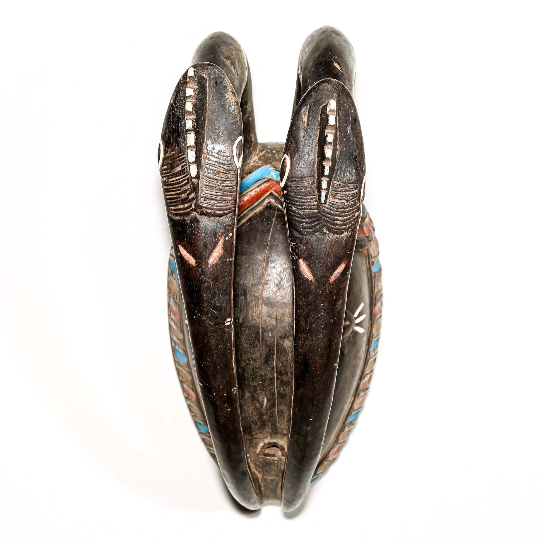 African art piece, specifically a yellow and blue wooden mask with geometric patterns on a white background. Tribal African art for sale.