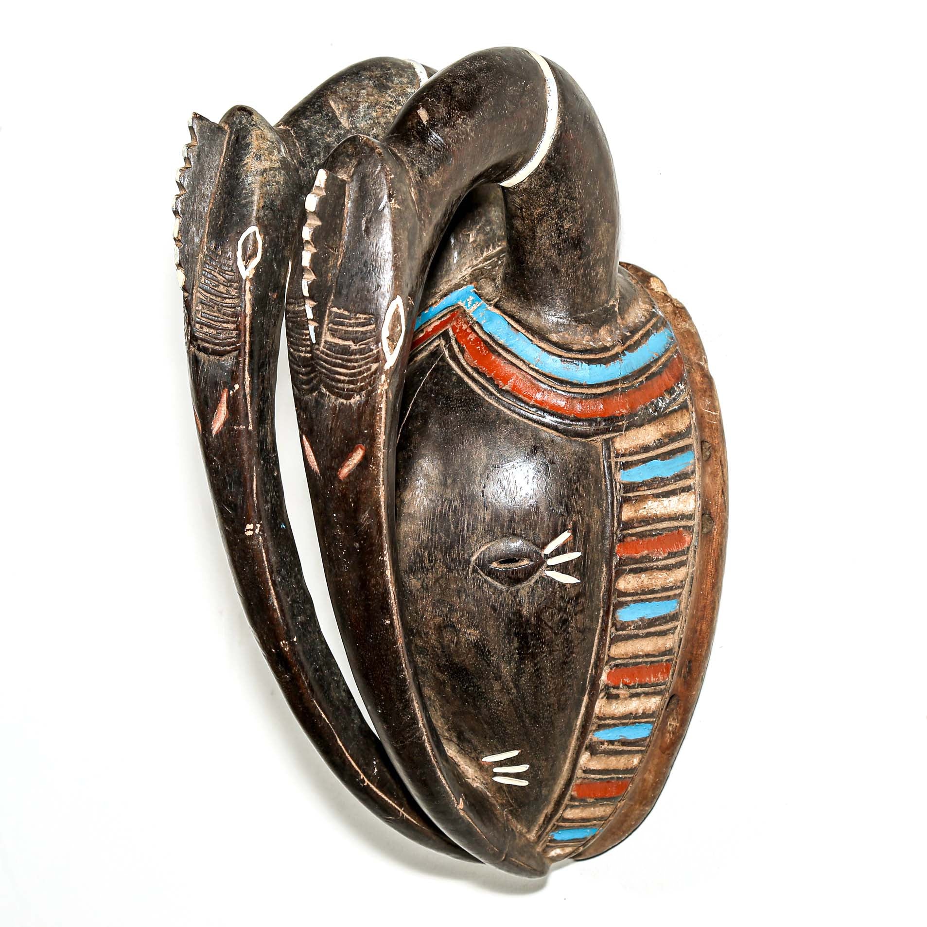 African art piece, specifically a yellow and blue wooden mask with geometric patterns on a white background. Tribal African art for sale.