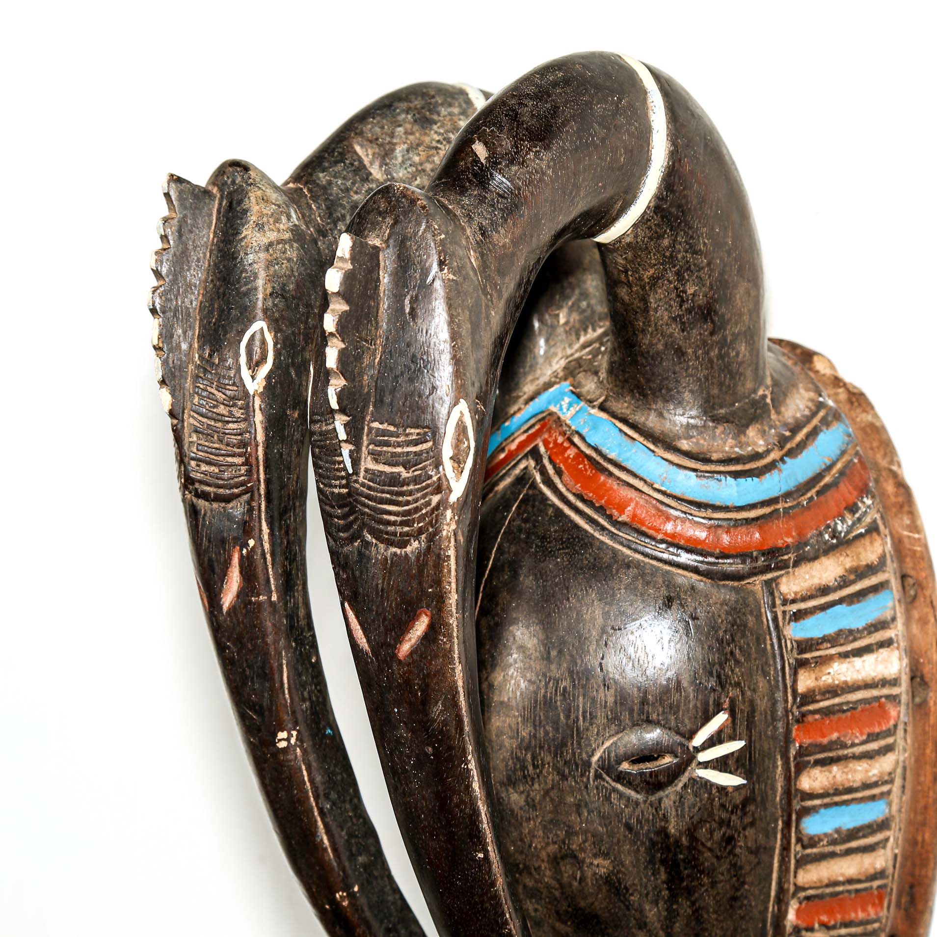 African art piece, specifically a yellow and blue wooden mask with geometric patterns on a white background. Tribal African art for sale.