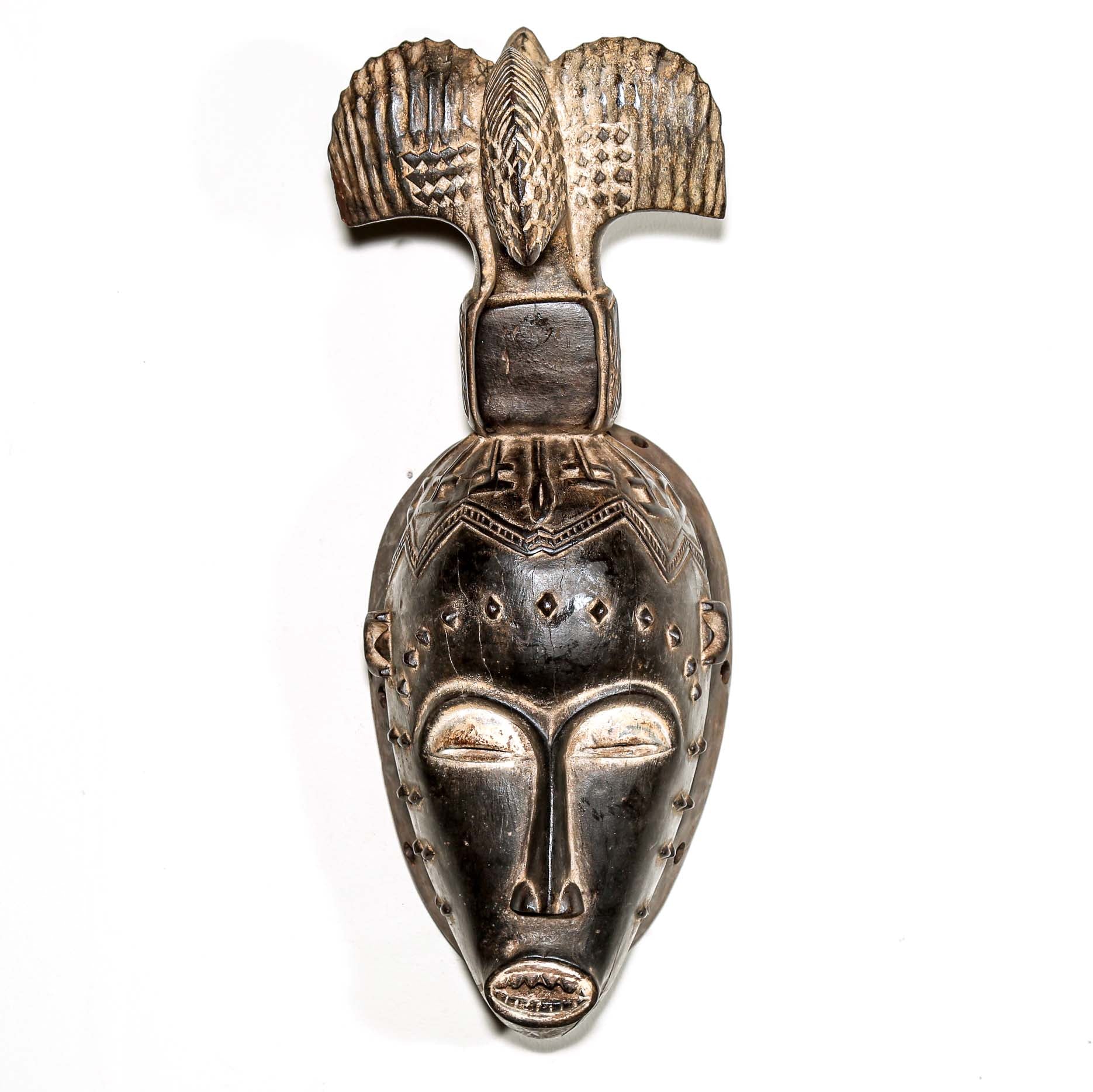 Fine African wood mask with intricate designs on a white background. Traditional tribal art for sale