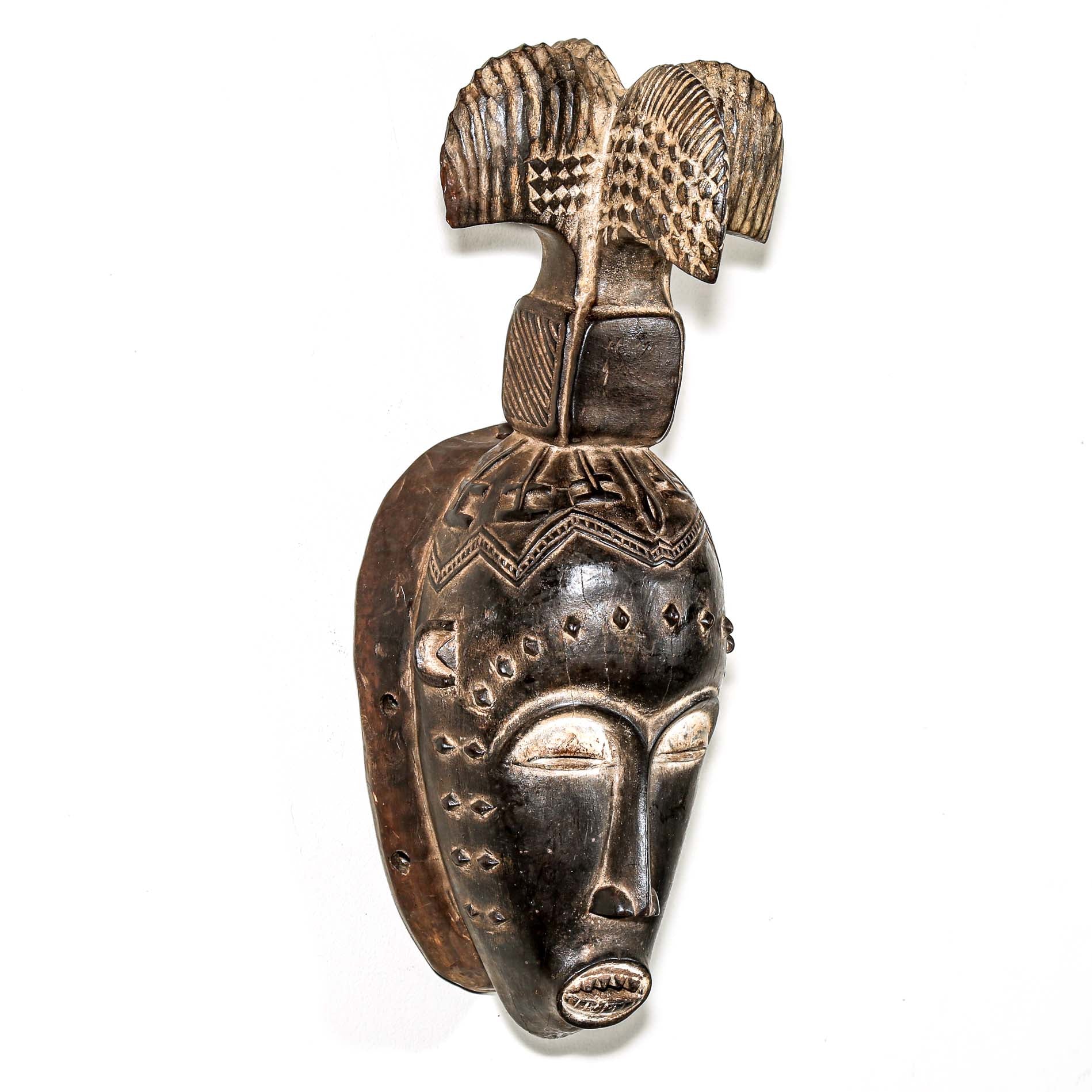 Fine African wood mask with intricate designs on a white background. Traditional tribal art for sale