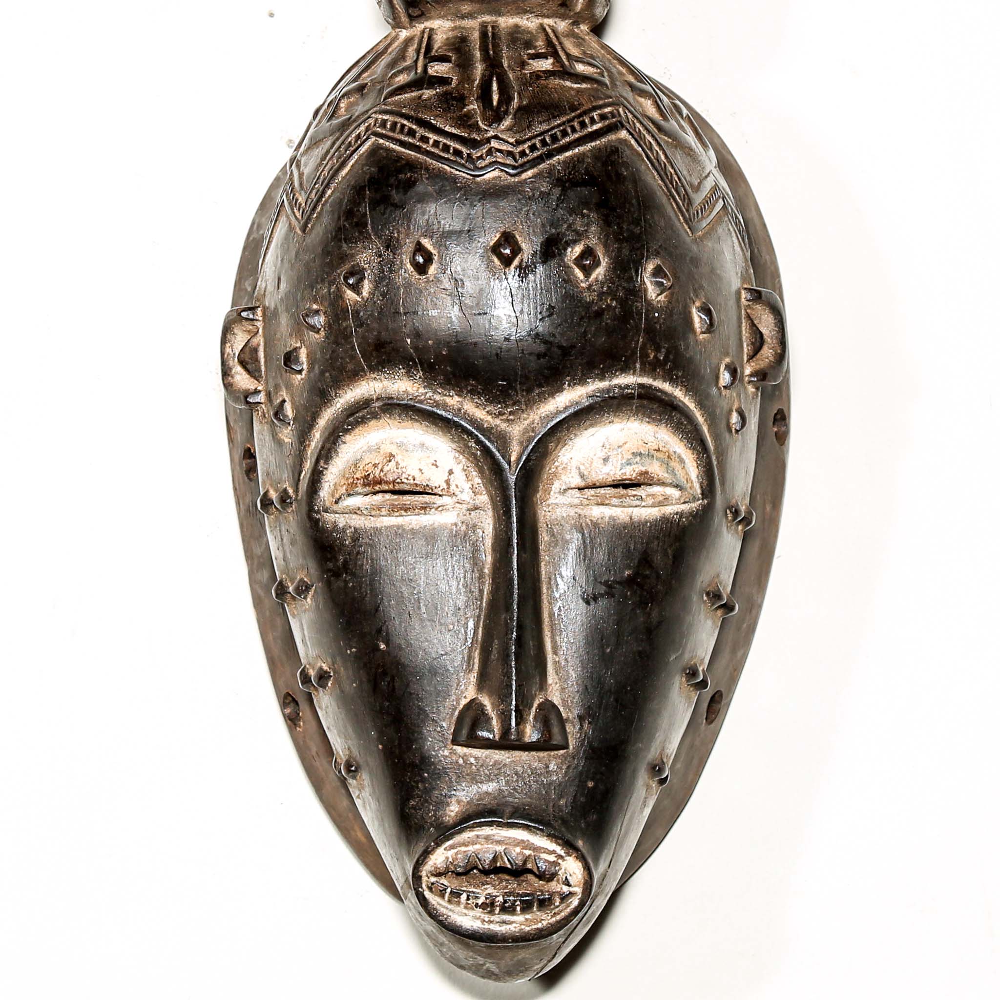 Fine African wood mask with intricate designs on a white background. Traditional tribal art for sale