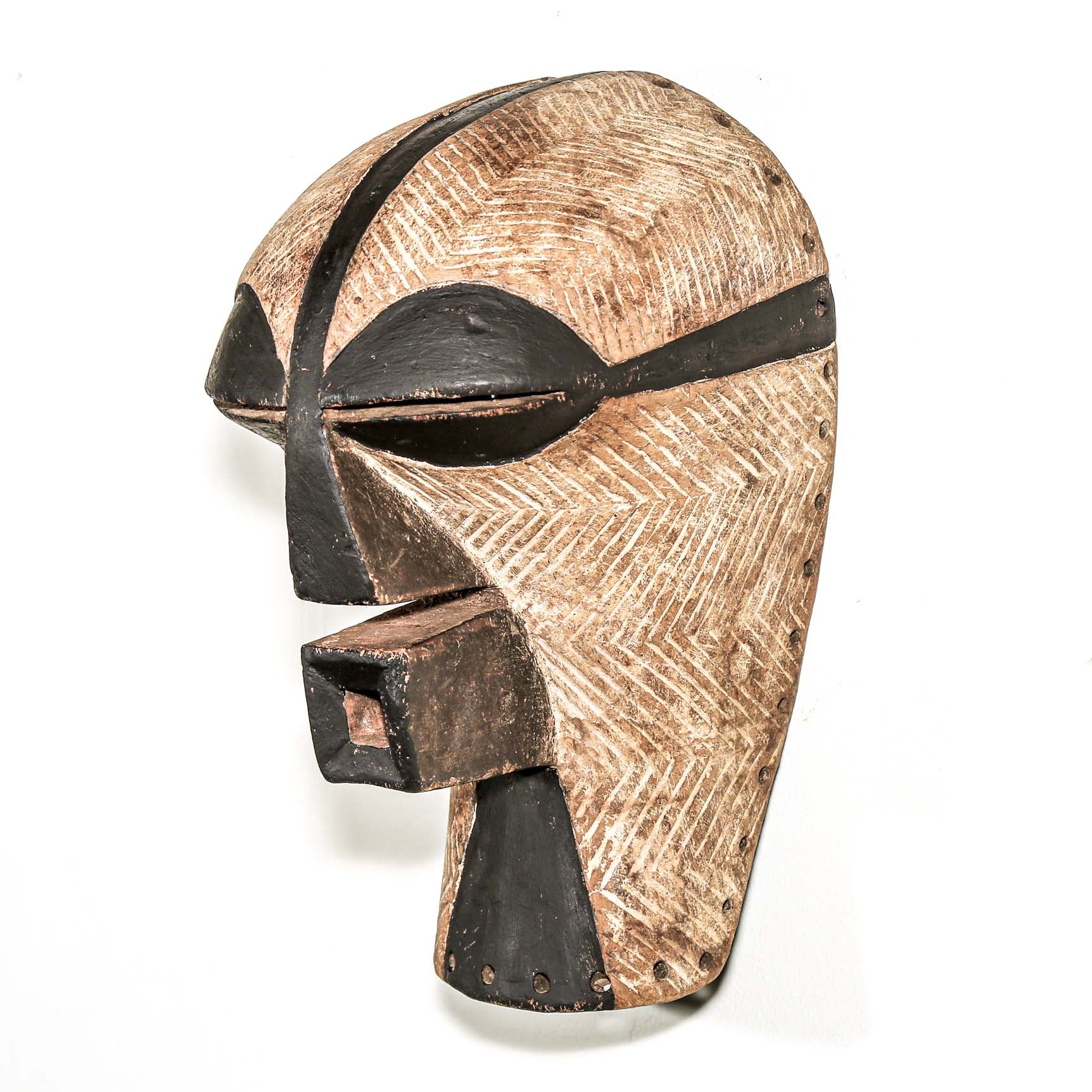 black and white Wooden african ceremonial mask with black accents on a white background