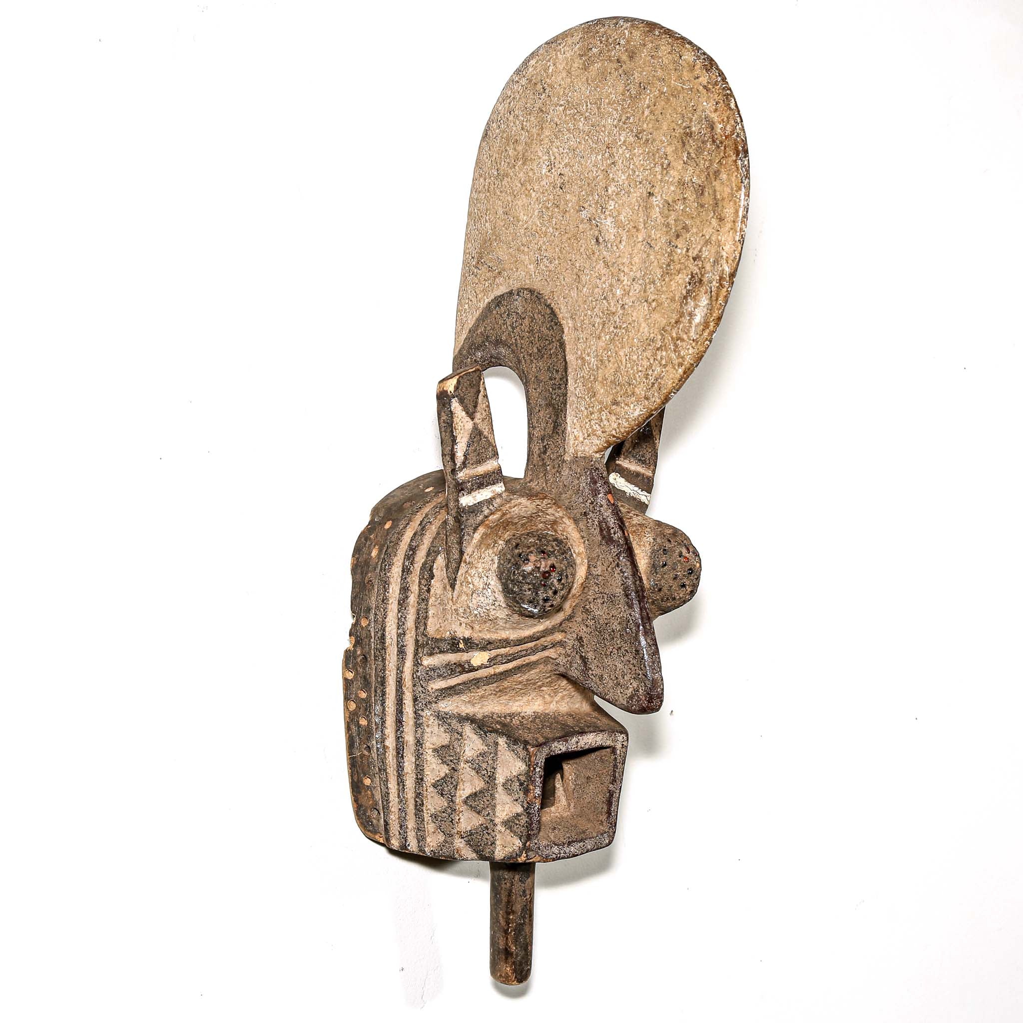 wood African mask black art colors hanging on a bedroom wall. African art for sale for collectors