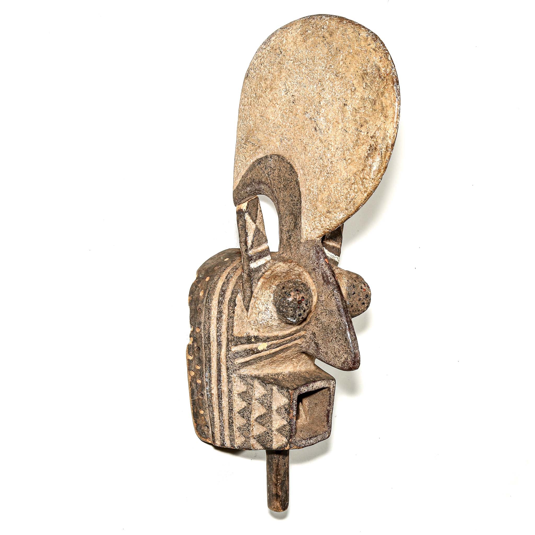 wood African mask black art colors hanging on a bedroom wall. African art for sale for collectors