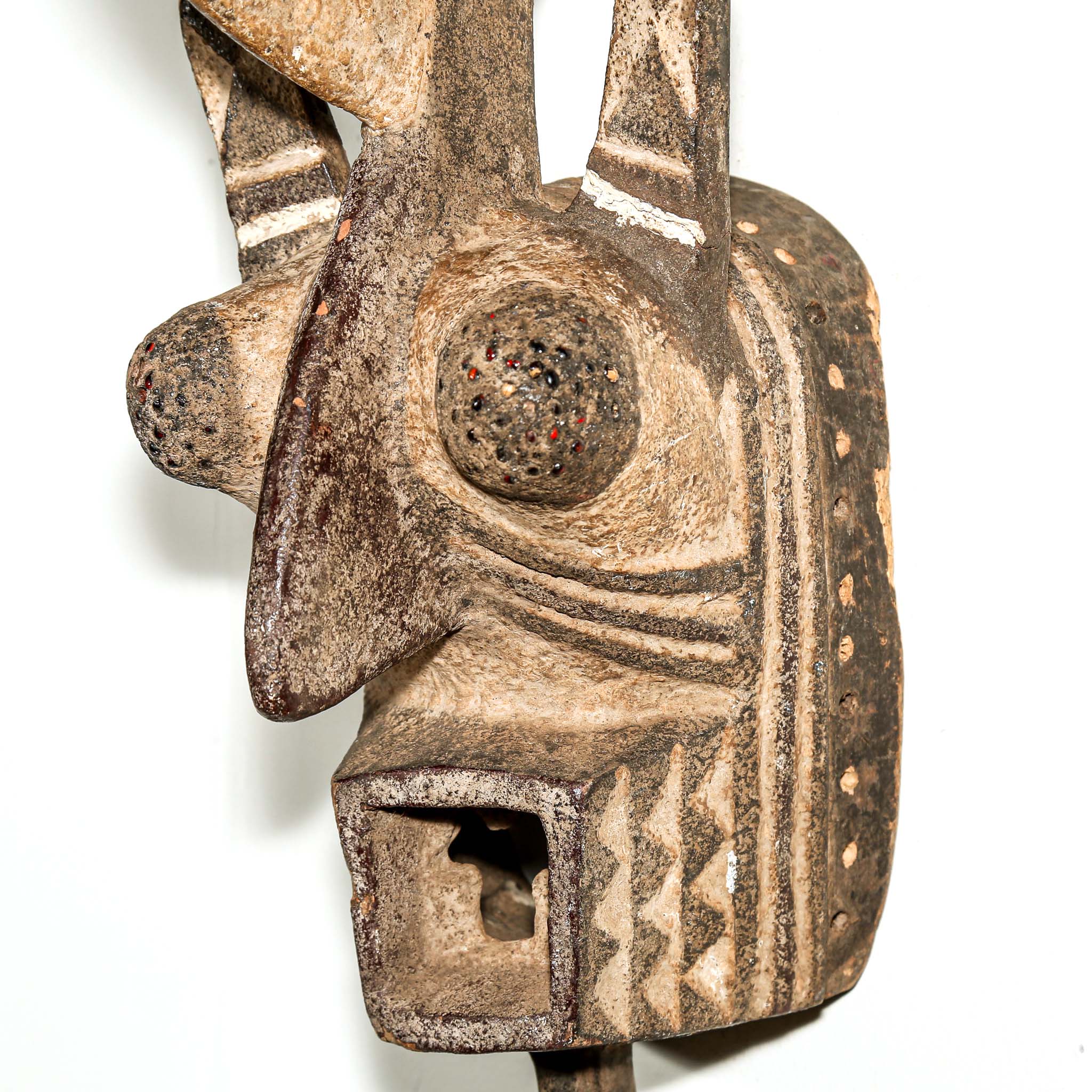 wood African mask black art colors hanging on a bedroom wall. African art for sale for collectors