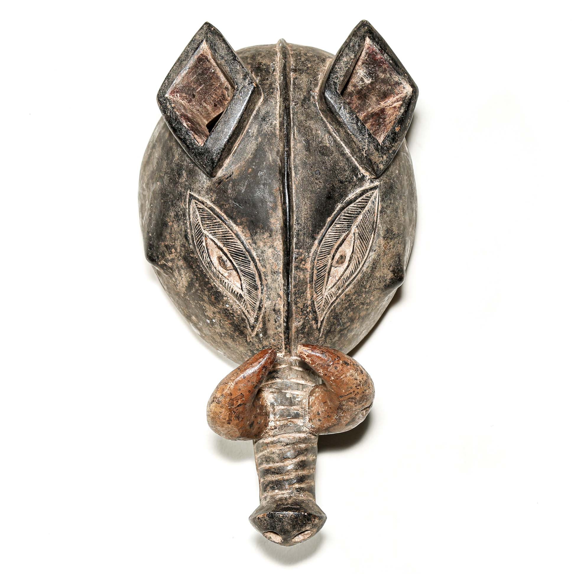 Finely carved wooden mask from Africa with intricate designs on a white background. Traditional artwork for collectors