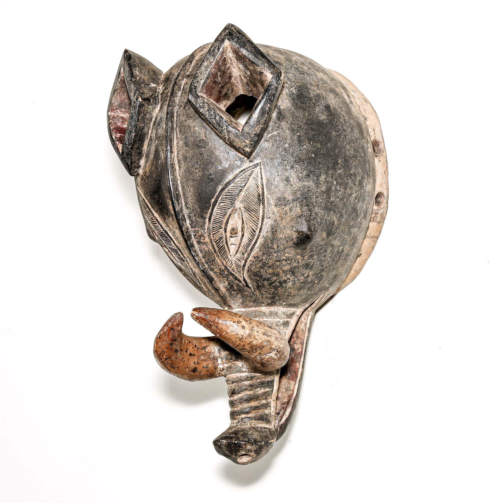 Finely carved wooden animal mask from Africa with intricate designs on a white background. Traditional artwork for collectors