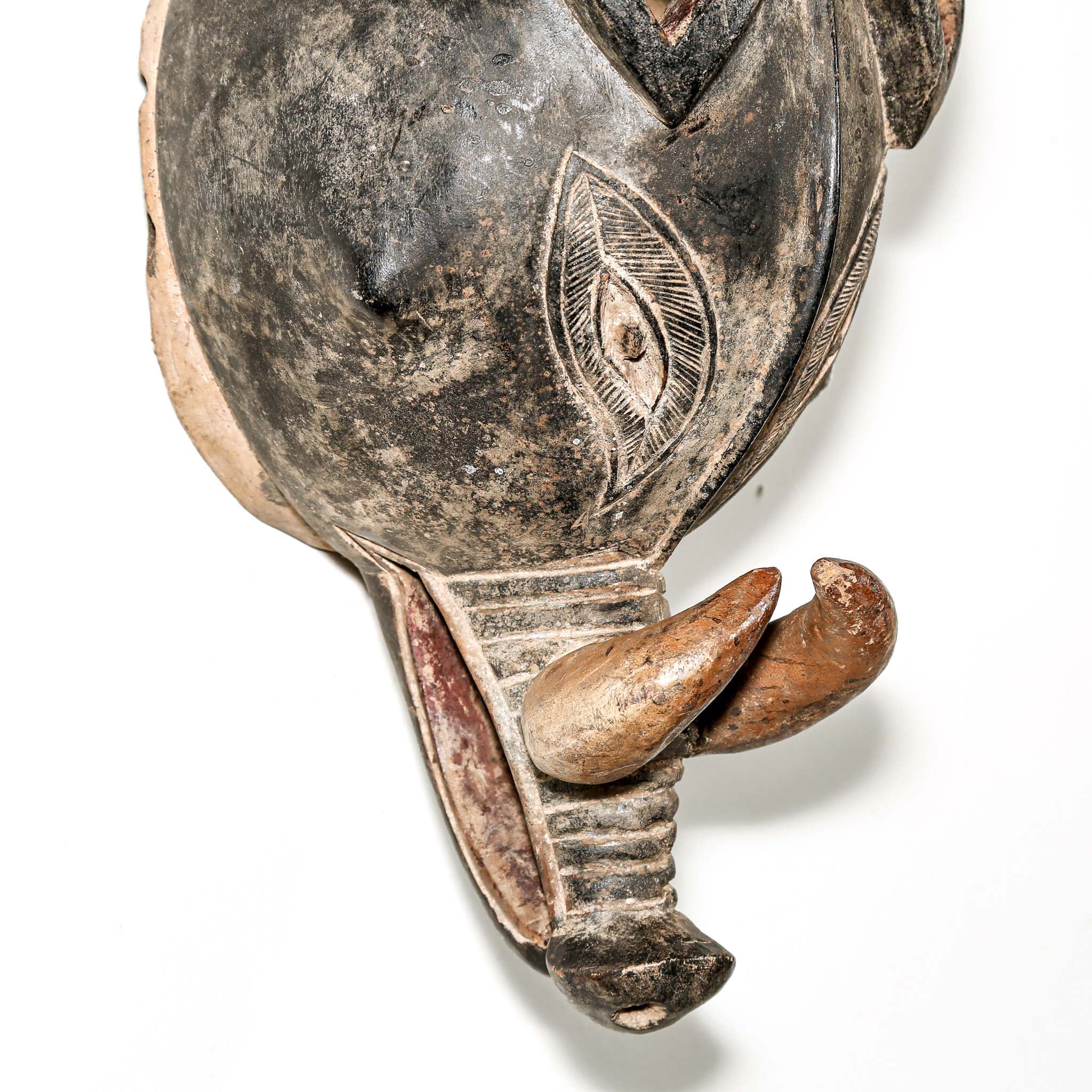 Finely carved wooden animal mask from Africa with intricate designs on a white background. Traditional artwork for collectors