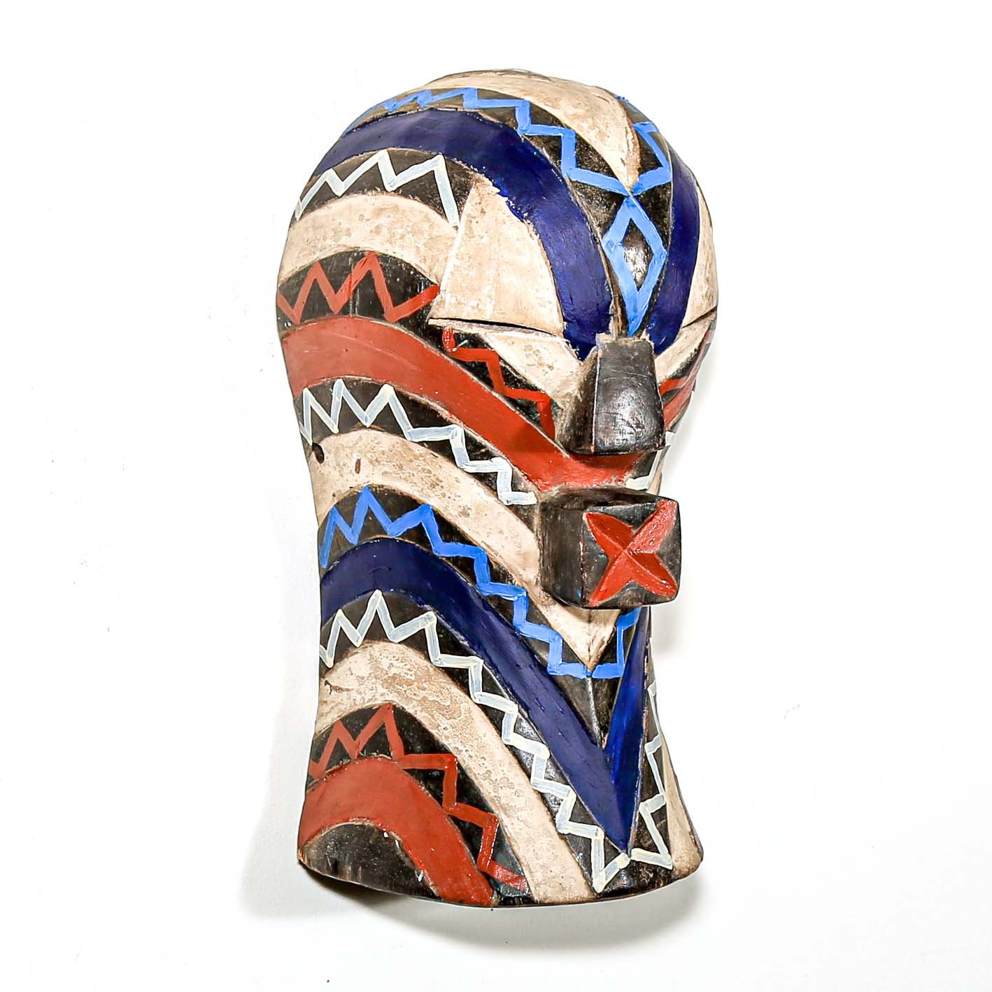 Colorful modern tribal art from African for sale. Songye ceremonial mask hanging on a white wall
