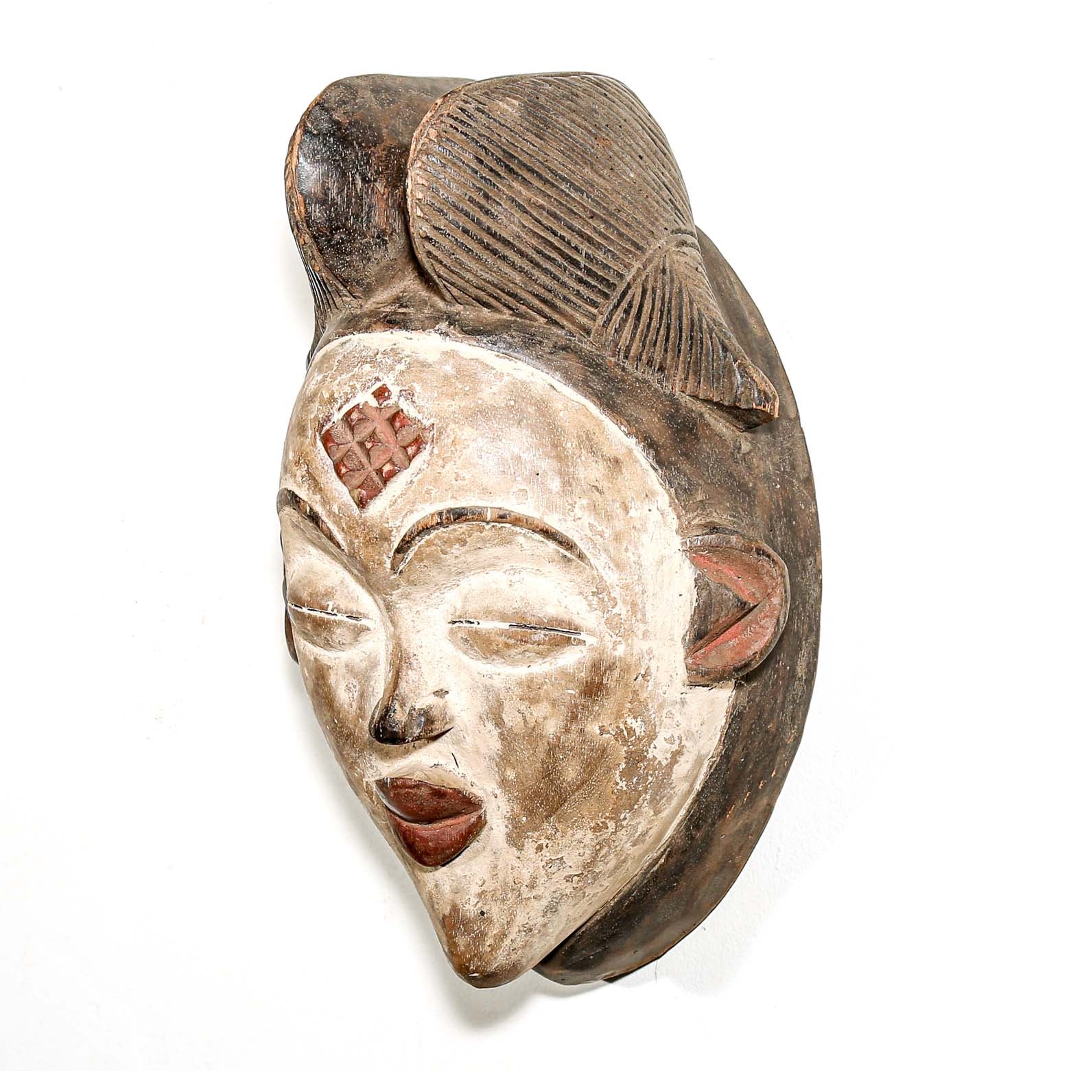 Wooden mask with detailed carvings on a white background