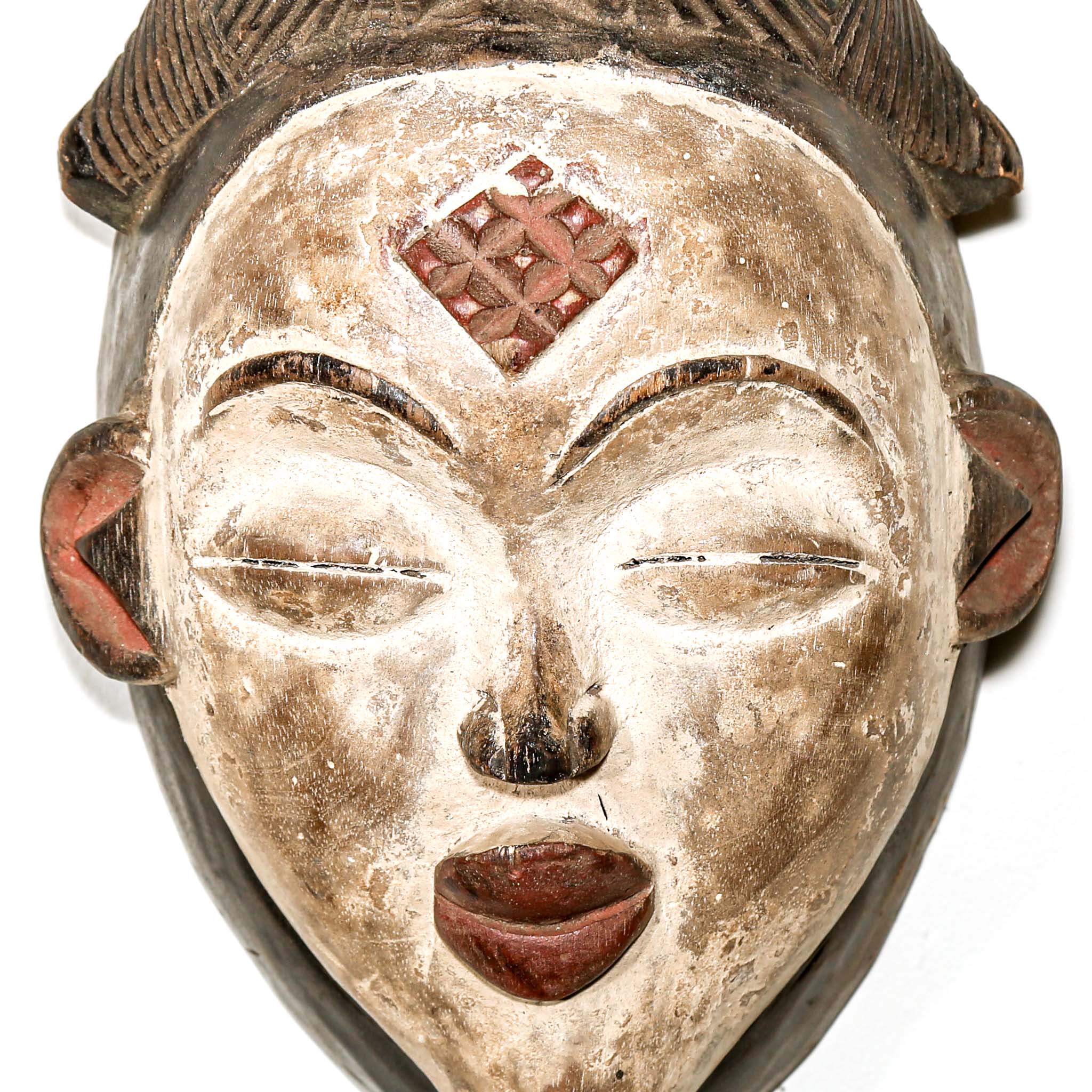 Traditional wooden mask with a white face and brown accents on a white background