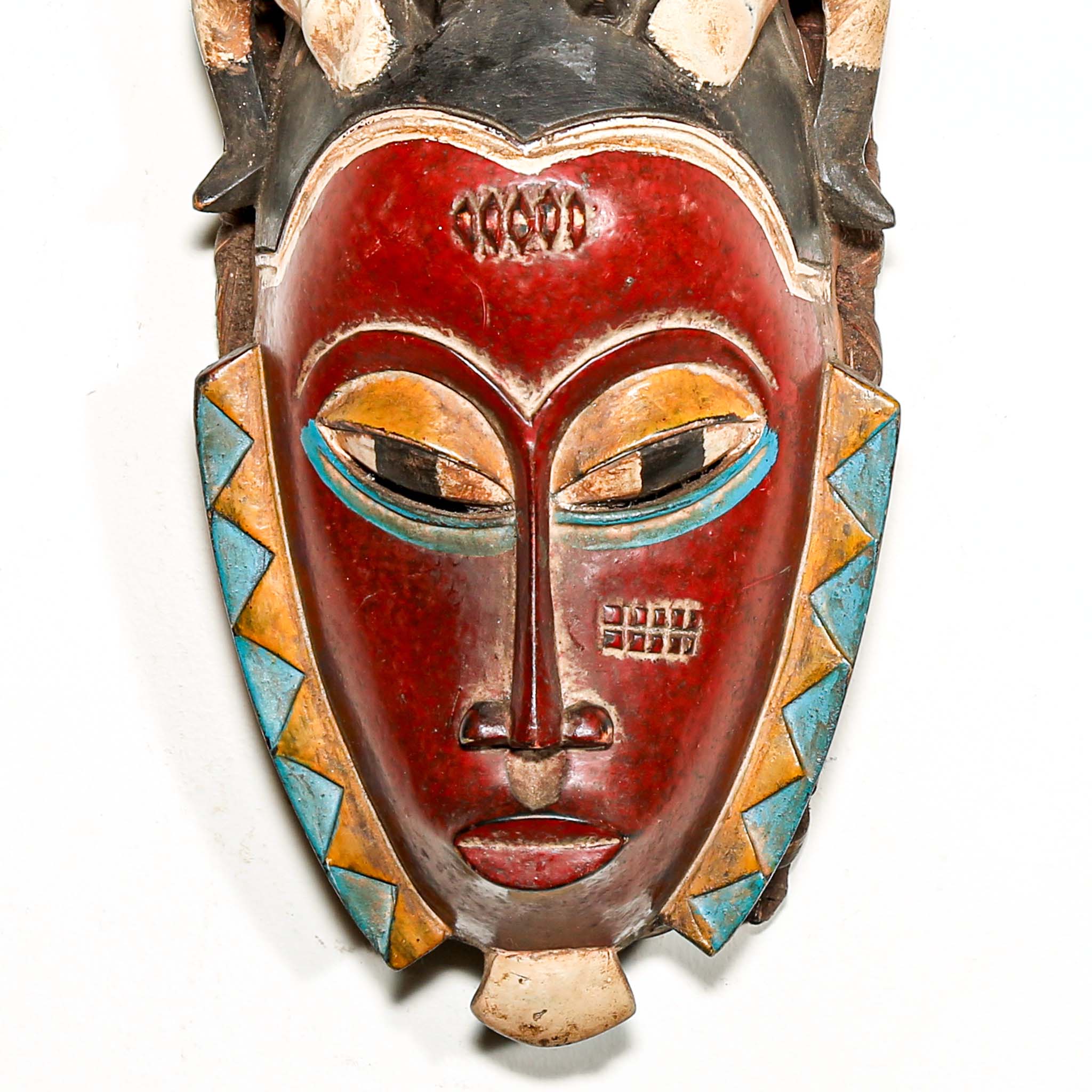 Colorful mask with red face and decorative patterns on a white background