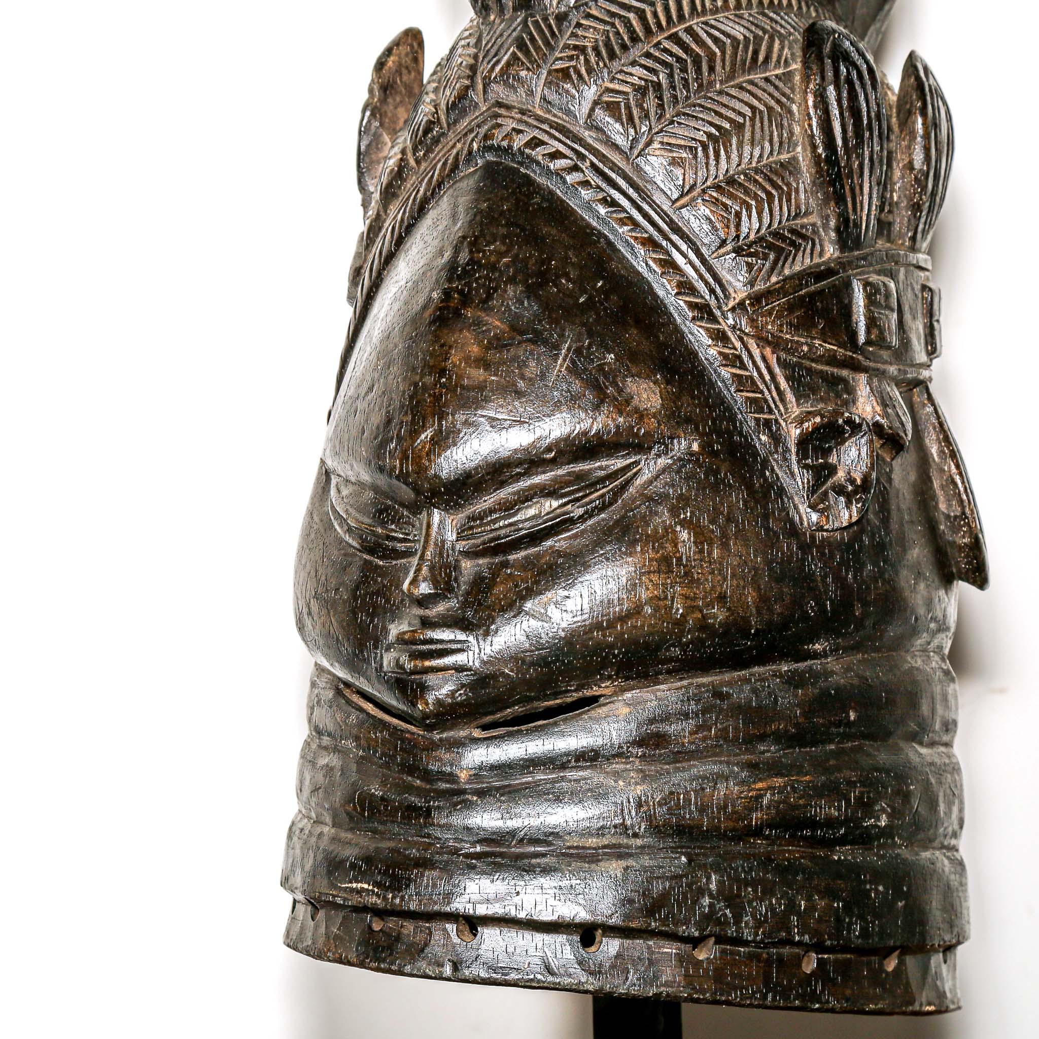Decorative black african mask on a wooden home side table against a white background