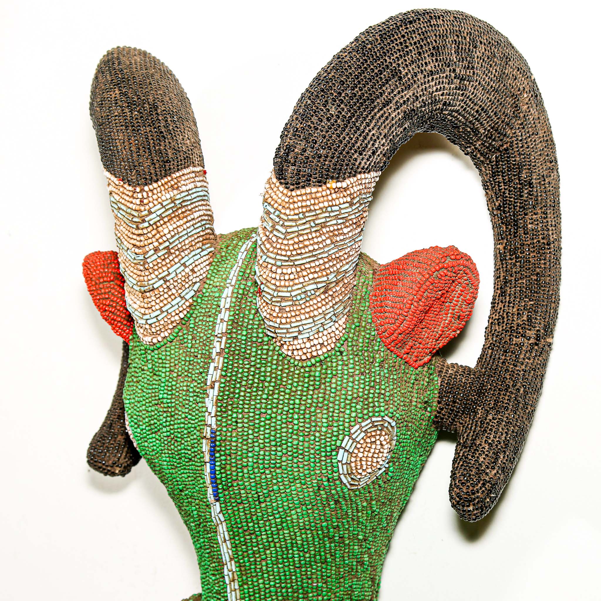 Decorative headpiece with beads and fabric on a white background