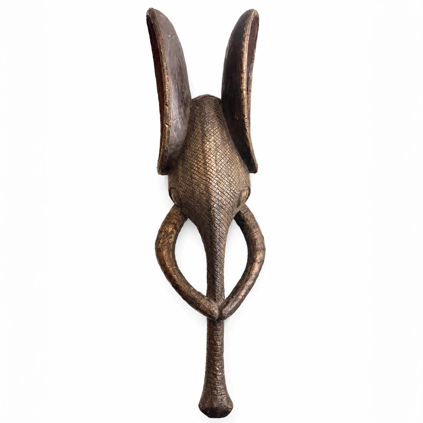 Decorative wall mask of a elephant from Africa made from wood and metal with a unique design on a white background