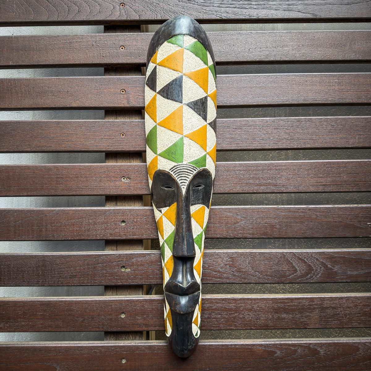 Colorful Fang-style mask from Gabon with elongated carved facial features and bold painted decorative details