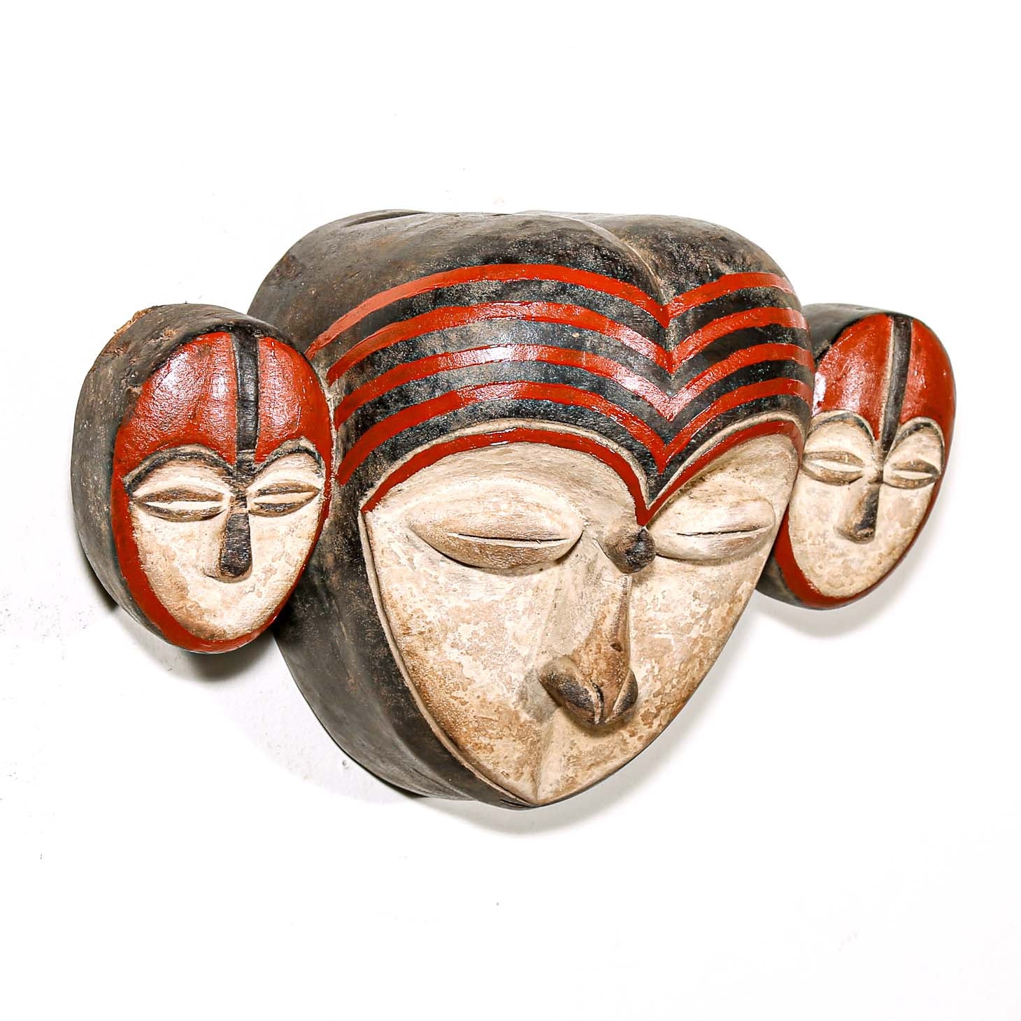 Carved wooden mask with red and black patterns on a white background