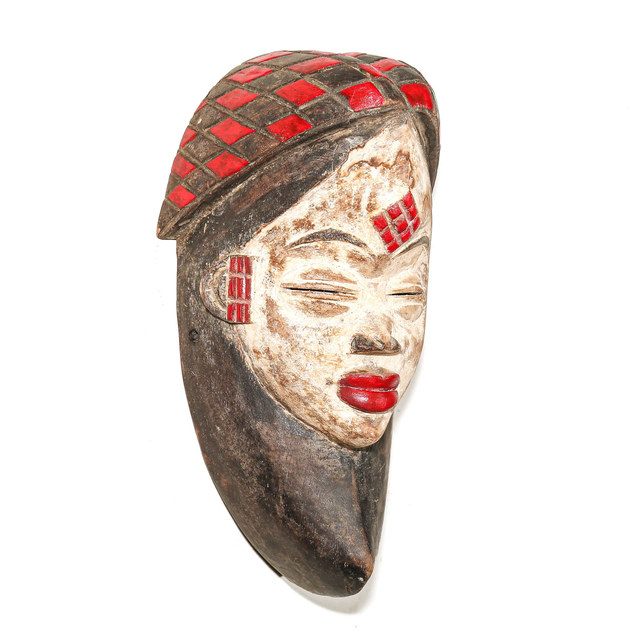 A carved African-style wooden mask with a dark brown base, beige-painted face, and red inlaid geometric patterns on the hat and forehead, shown against a plain white background.