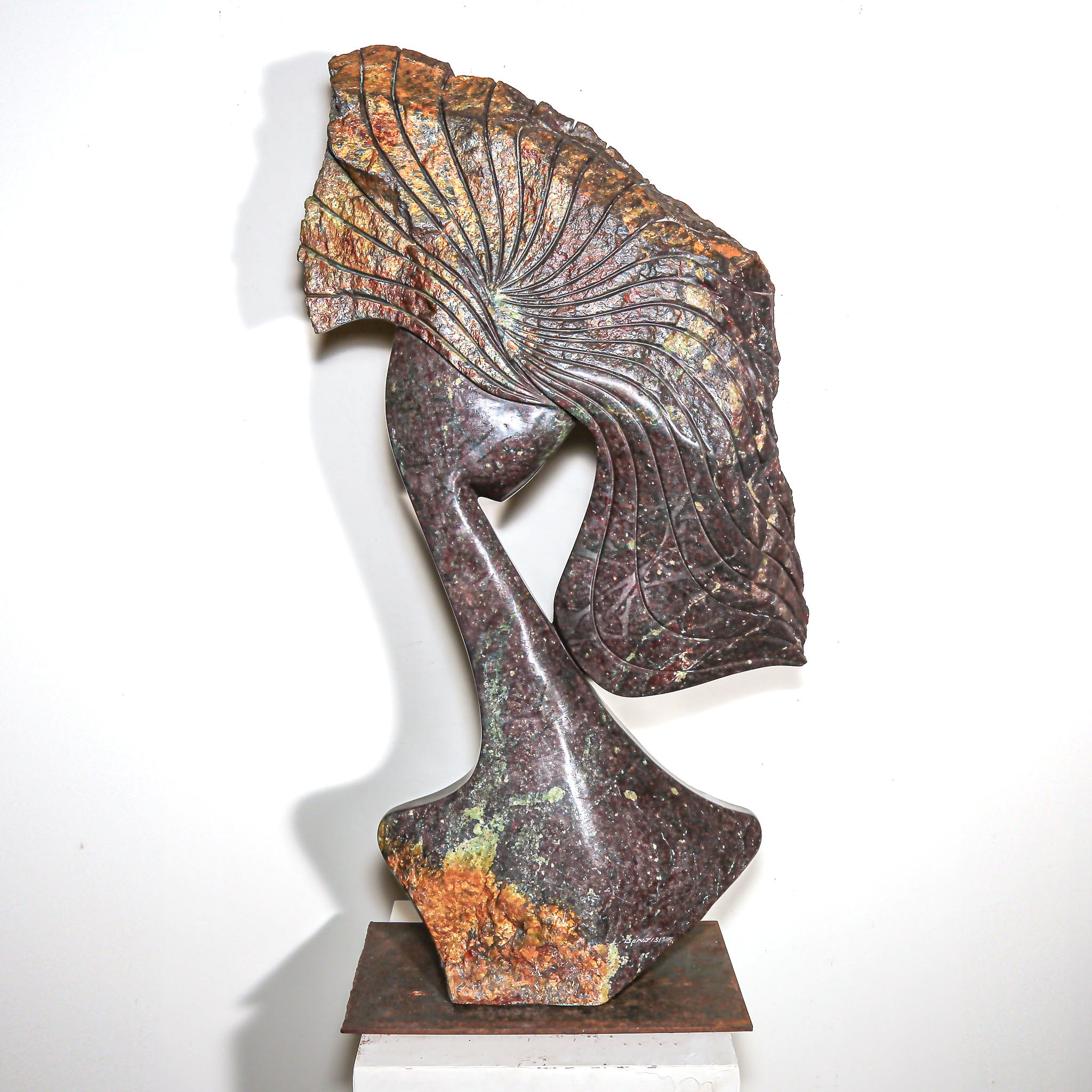 Purple Stone Sculpture of a Woman Titled "Windswept" by Lovemore Bonjisi displayed on a white pedestal
