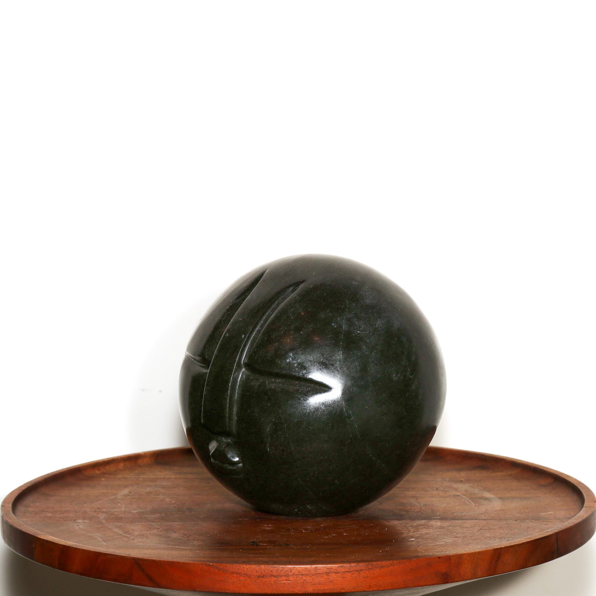 "Man in the Moon" Abstract Sculpture. Polish sphere of black stone with a carved abstract face