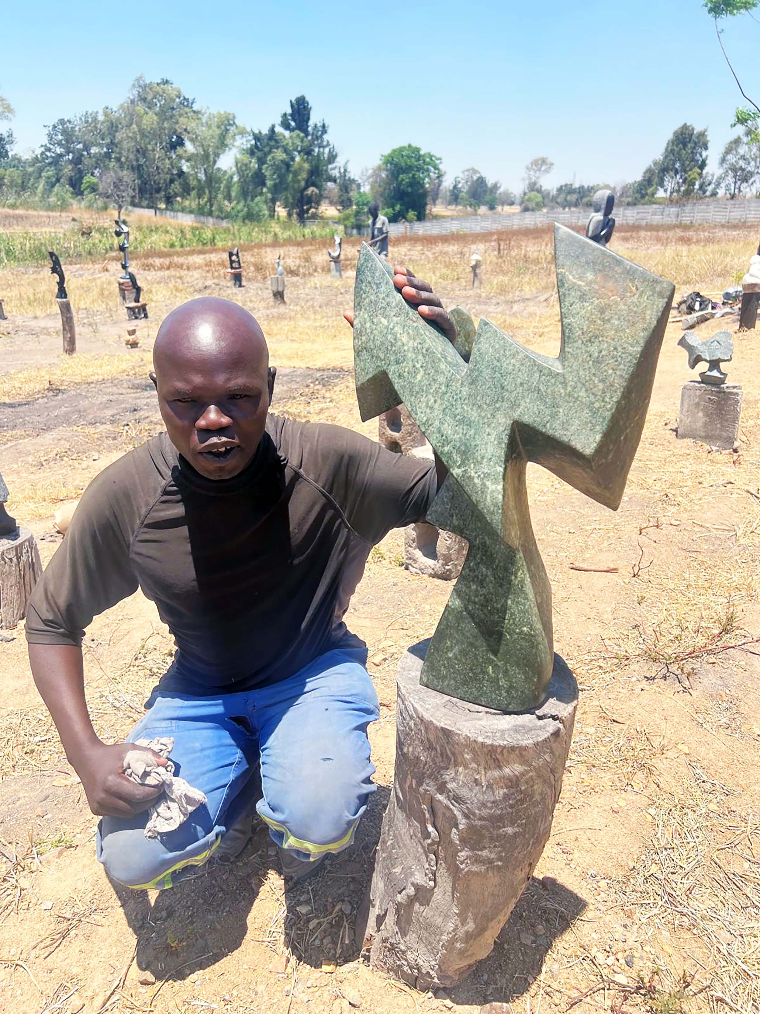 African artist with his stone sculpture in Zimbabwe