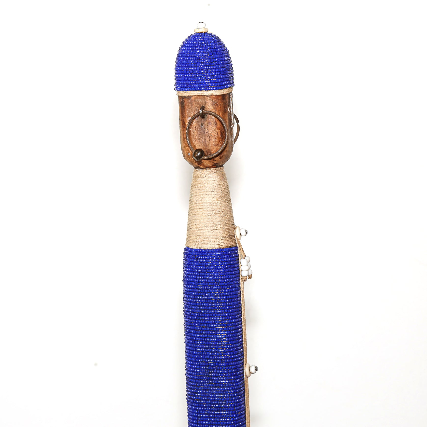 A traditional African beaded staff or wand featuring a blue beaded top, a natural wood face with a metal ring, a beige wrapped middle section, and a long blue beaded lower section with silver metal accents, set against a plain white background.