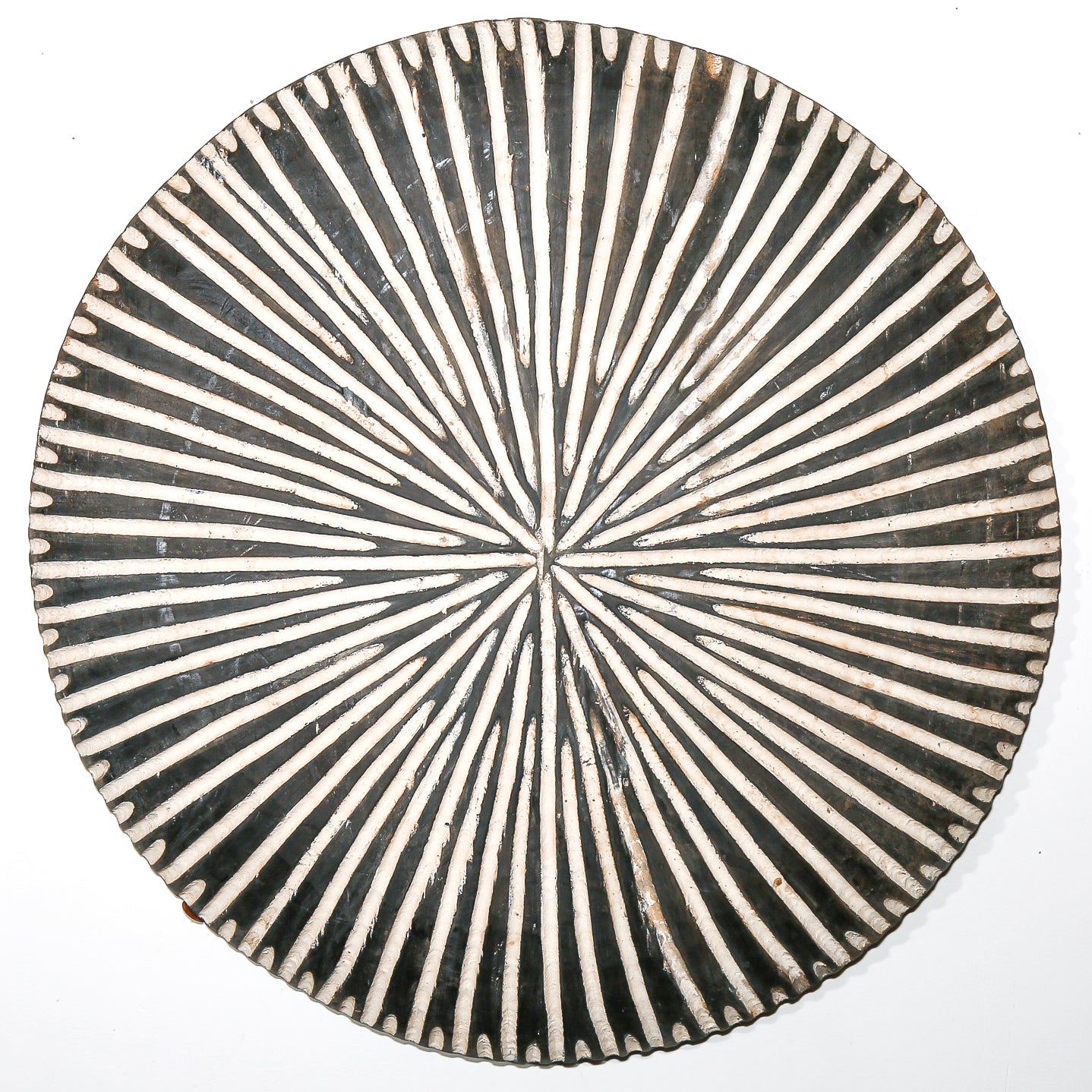 Round wood African art wall hanging for sale with black and white striped pattern on a white background living room design
