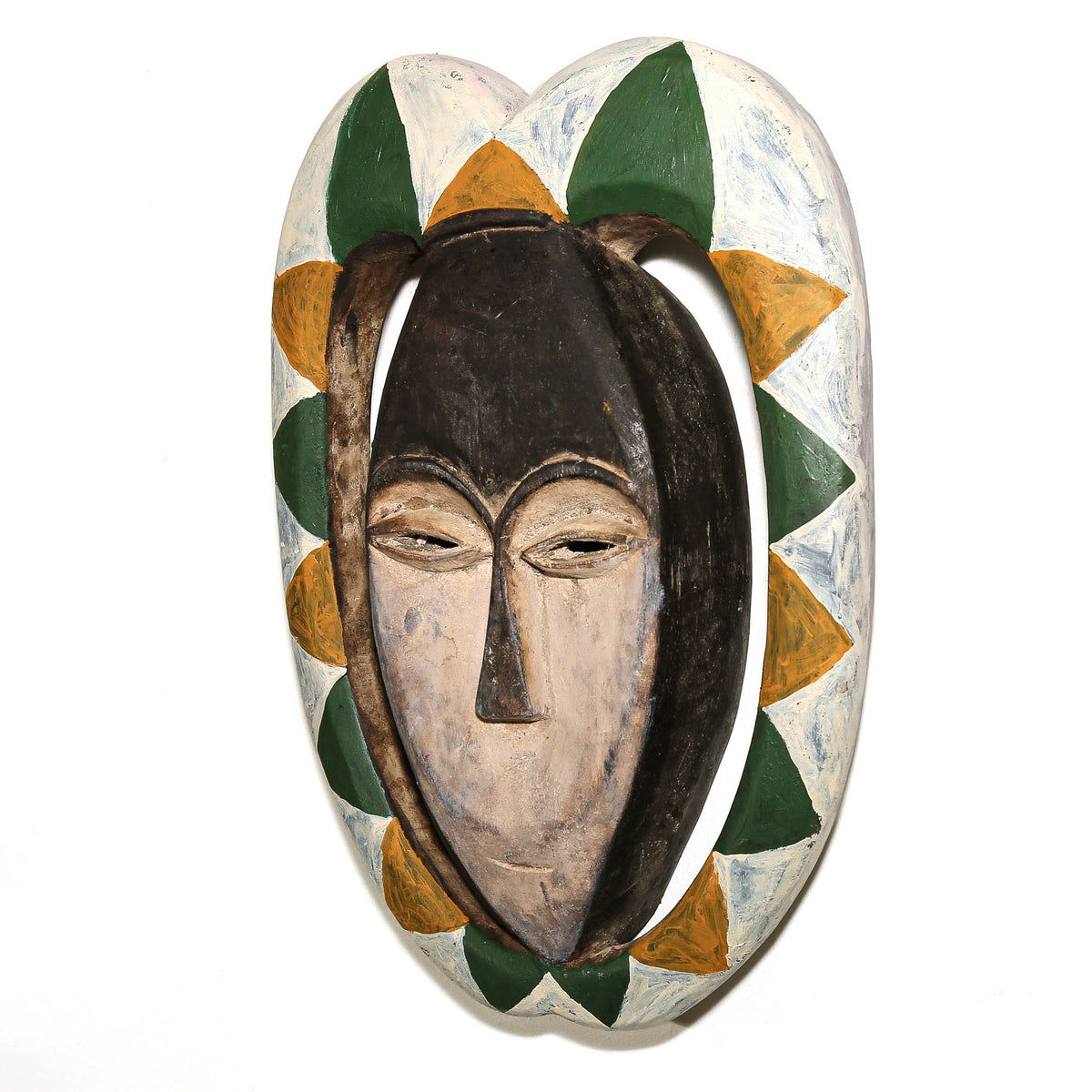 Traditional Kwele face mask featuring green, yellow, and white decorative patterning on a sculptural wood surface