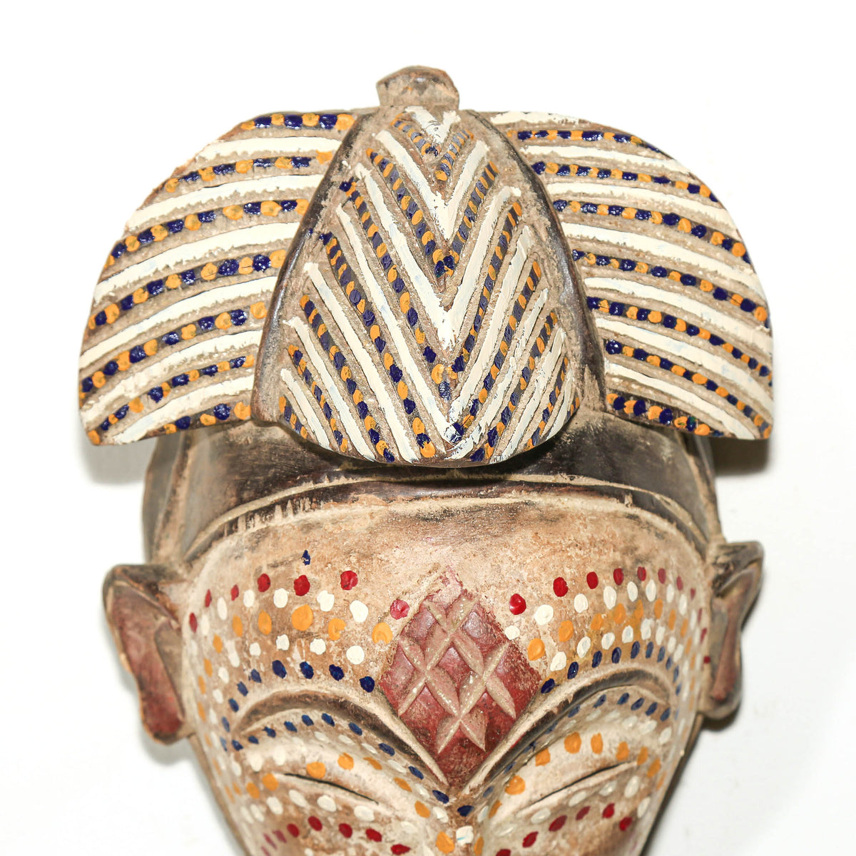 Traditional Punu face mask from Gabon featuring dotted decoration, elegant proportions, and carved wood construction