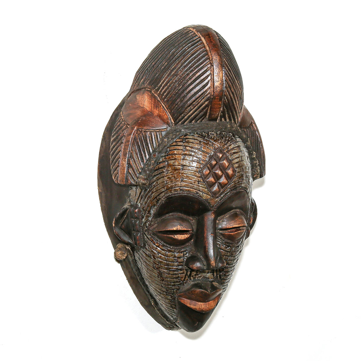 Traditional Punu mask with applied metal details, smooth carved surfaces, and expressive facial features from Gabon