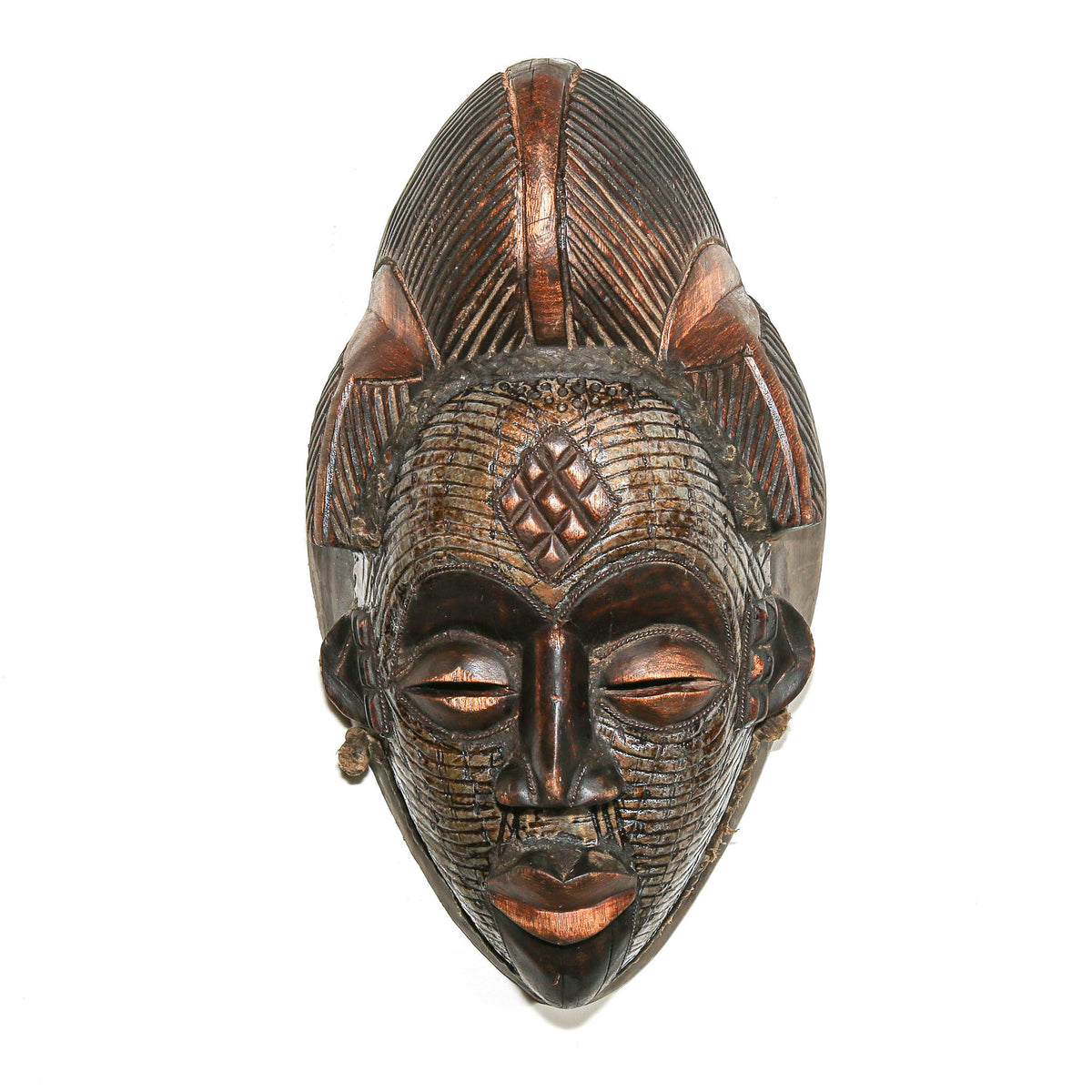 Collectible Punu mask from Gabon with carved wood construction and decorative metal elements adding texture and visual interest