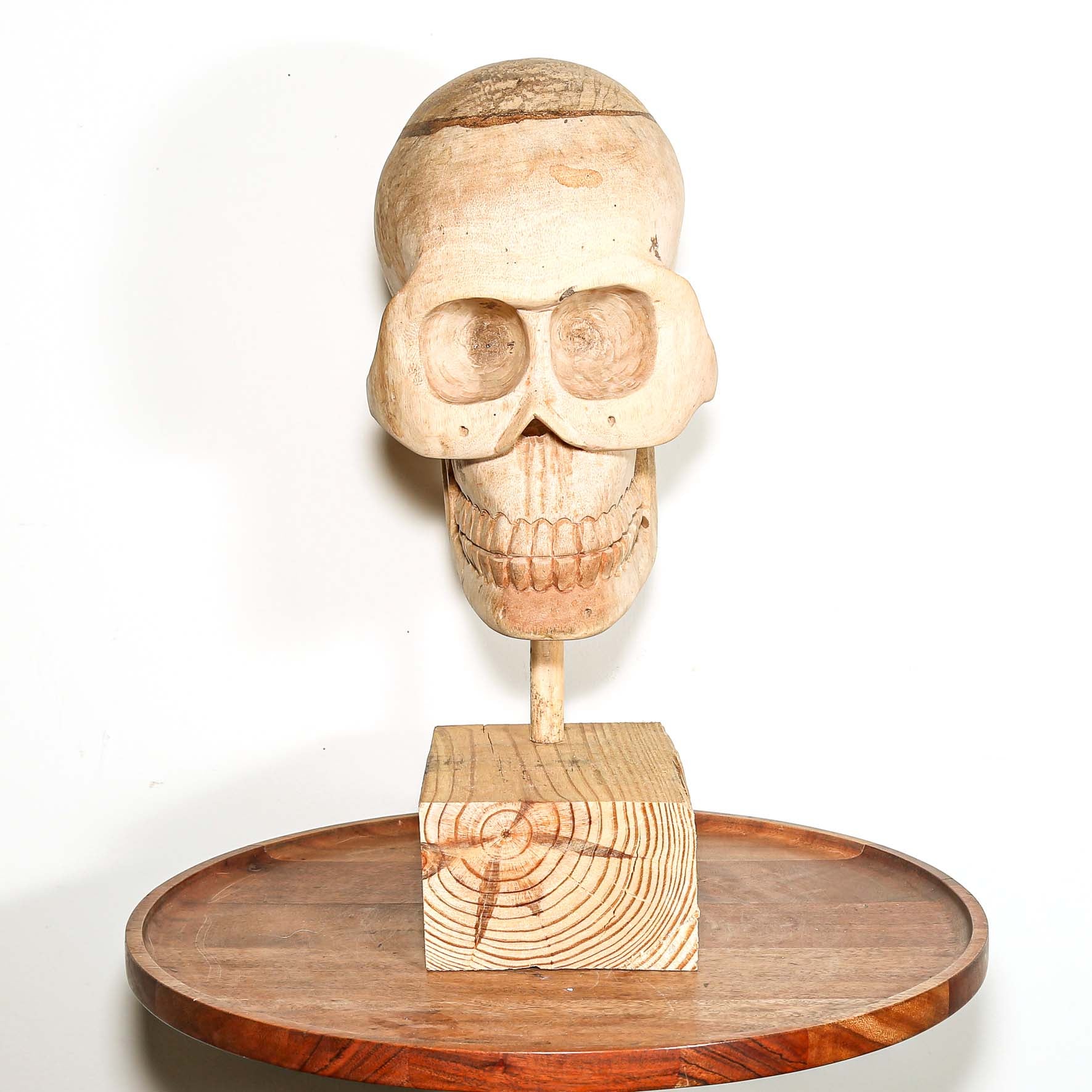 Wooden Skull sculpture on a stand with a white background made in Africa
