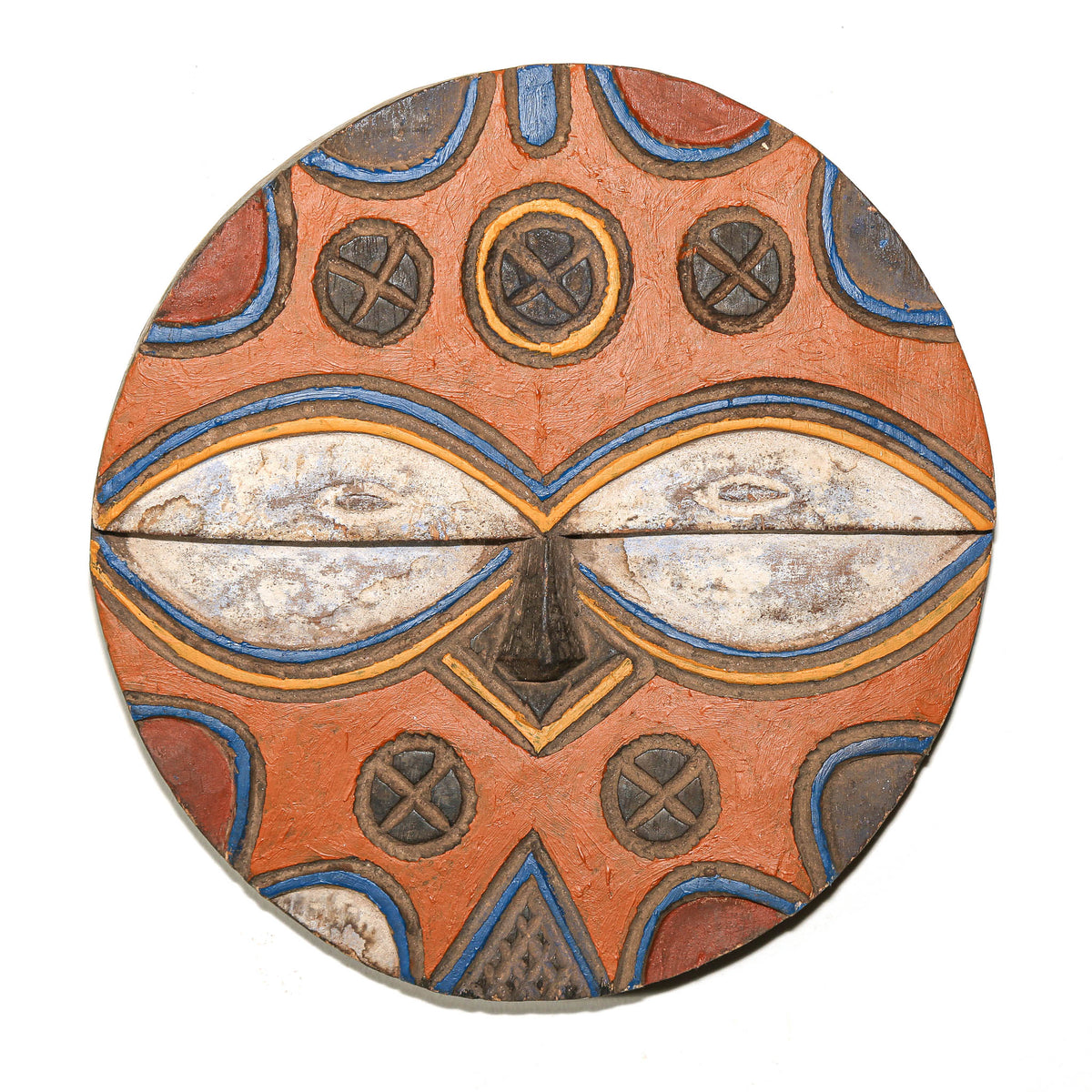 Colorful Central African Teke mask with circular shape, carved facial features, and vibrant geometric patterning