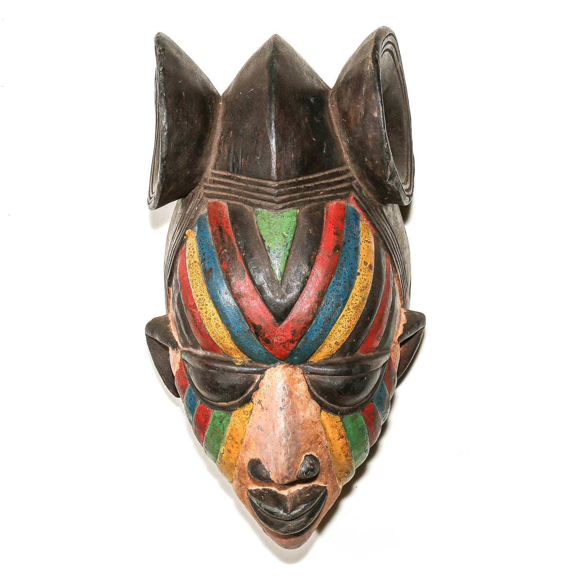 A carved wooden African-style mask with a dark brown base and vibrant painted accents of red, yellow, green, and blue on the face, photographed against a plain white background.