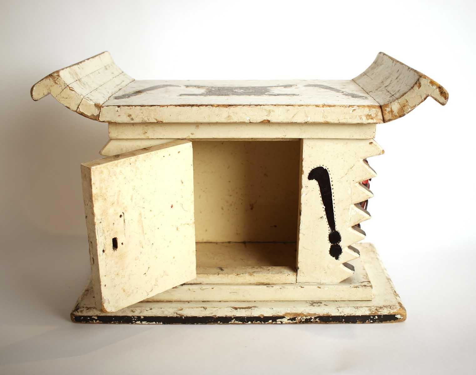 White wooden African stool furniture with cabinet and black distressed accents on a wooden living room floor