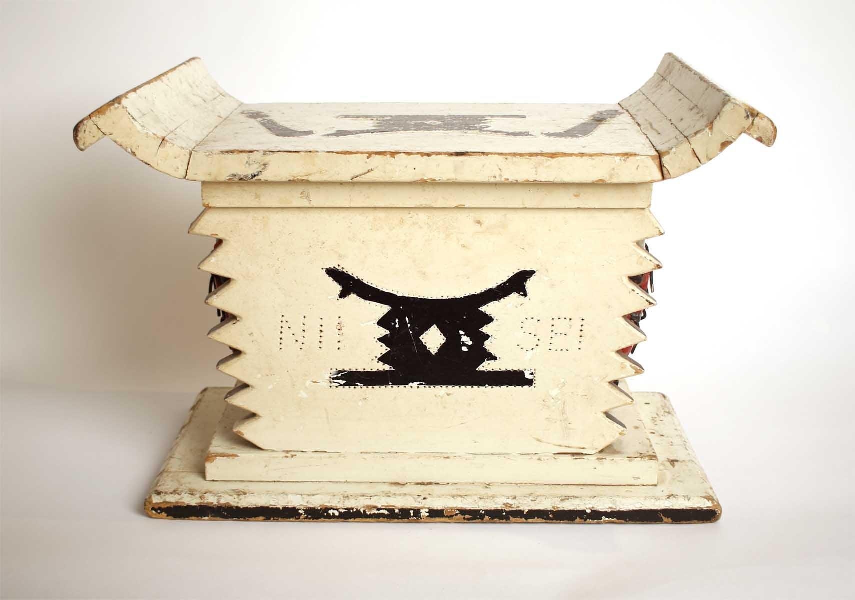 White wooden African stool furniture with cabinet and black distressed accents on a wooden living room floor