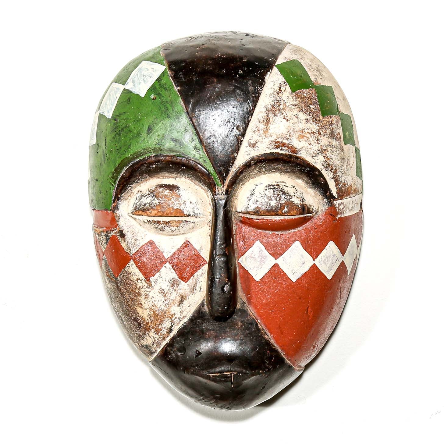 Colorful Aduma African wood mask with geometric patterns on a white bedroom wall