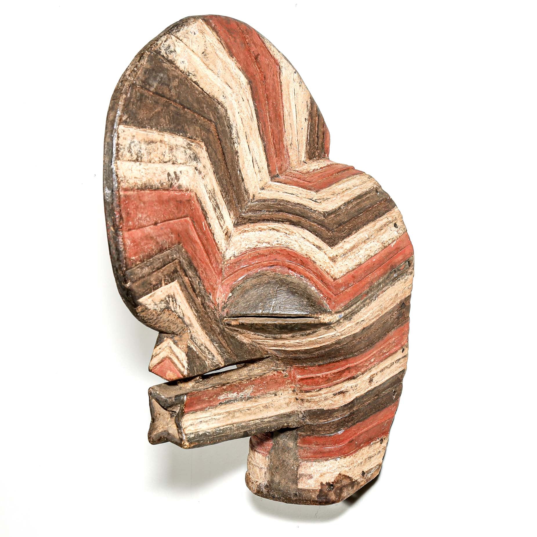 colorful Wooden African mask with striped pattern hanging on a white wall for sale