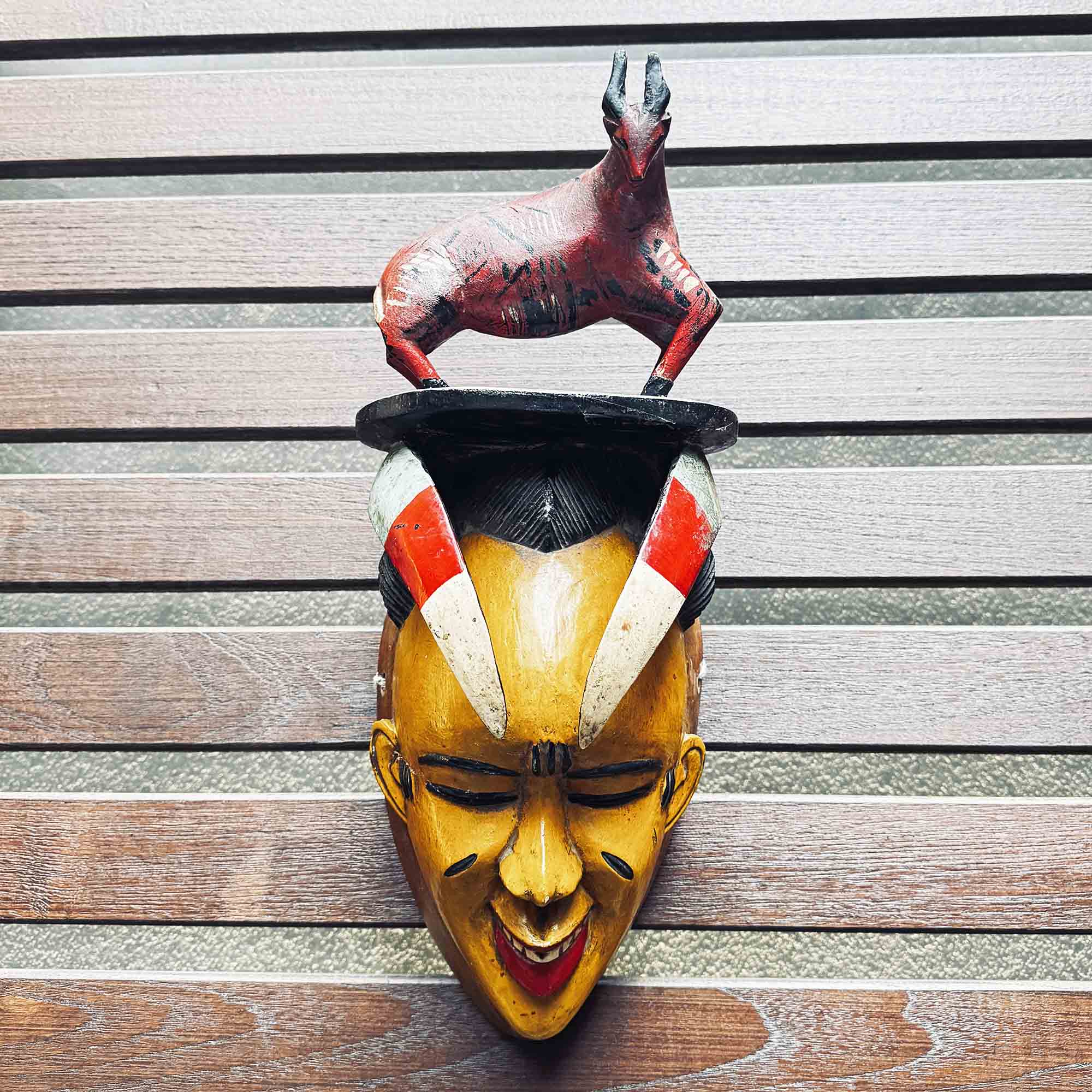 yellow and red mask with unique hang-made bull on the head handing on a wall