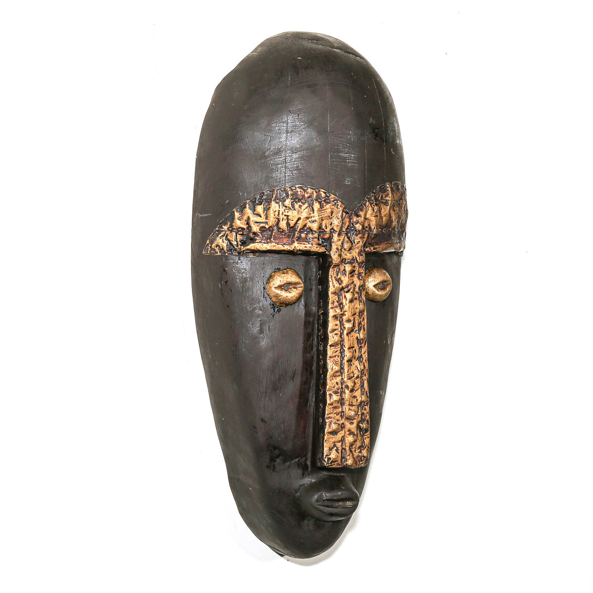 A dark carved wooden African-style mask with gold-painted facial details, photographed against a plain white background.